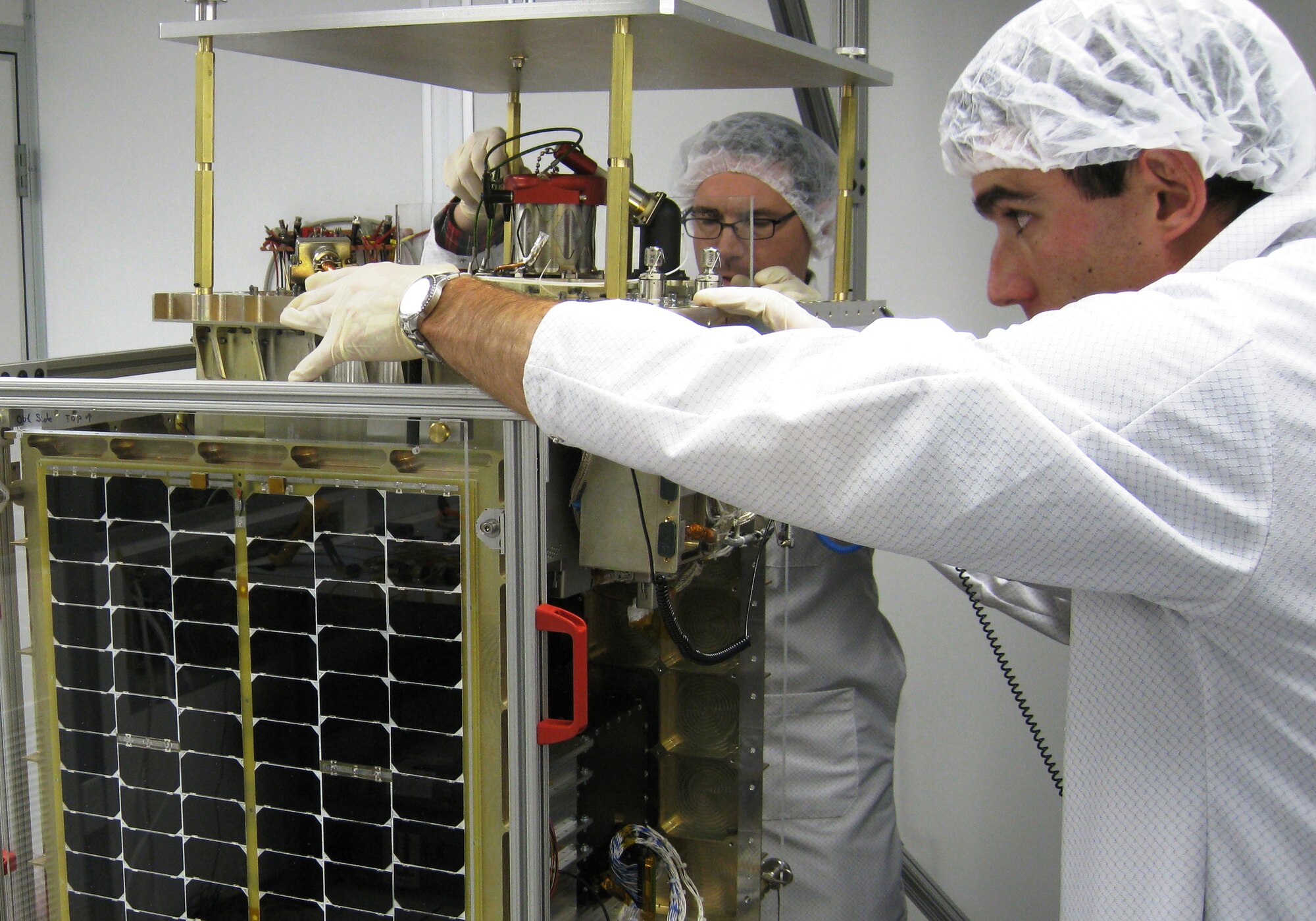 Pat O'Grady from InStar Engineering and Eric Ehrbar from Busek Inc. confirm FalconSAT-5's fit check with its main payload, the Space Plasma Characterization Source, at the U.S. Air Force Academy in Colorado Springs, Colo., Sept. 28, 2009. FalconSAT-5 is an $11-million program sponsored by the Air Force Research Laboratory, headquartered at Wright-Patterson Air Force Base, Ohio. (U.S. Air Force photo/Maj. Steve Hart)