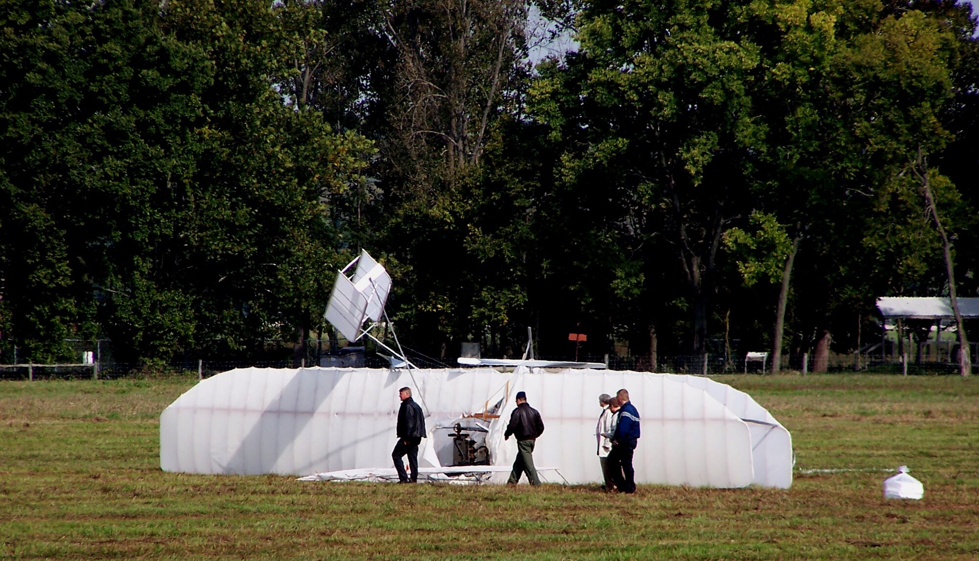 Air Force safety and airfield operations personnel inspect the wreckage of a replica 1905 Wright Flyer III that crashed Oct. 1, 2009 on Huffman Prairie Flying Field at Wright-Patterson Air Force Base, Ohio.  Pilot and vintage aircraft builder Mark Dusenberry of Dennison, Ohio was injured during a practice flight in preparation to celebrate the 104th Anniversary of Practical Flight. (Air Force photo/Ted Theopolos)