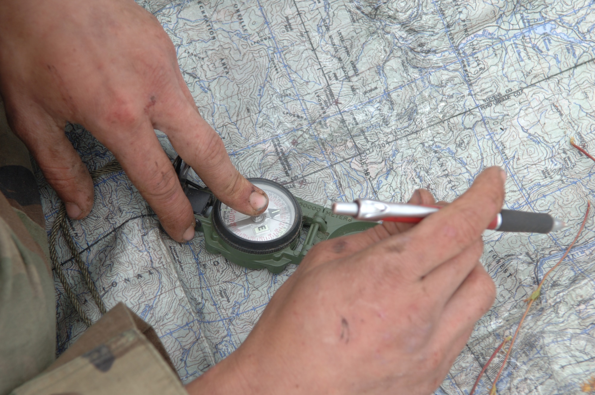 A Survival, Evasion, Resistance and Escape student plots points on a map during the Mobile phase of SERE training. (U.S. Air Force photo/Senior Airman Jocelyn Guthrie)