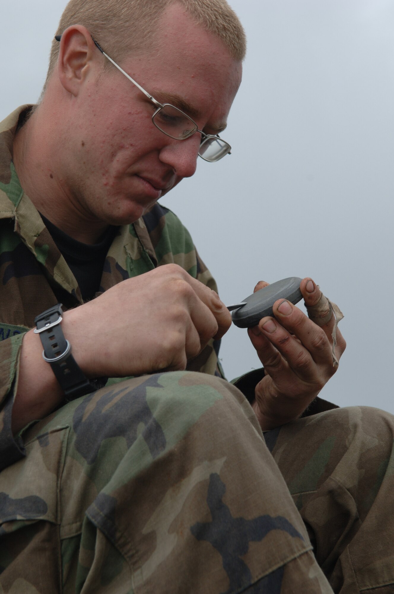 A Survival, Evasion, Resistance and Escape student sharpens a knife atop one of the highest peaks in the Colville National Forest during the Mobile phase of SERE training. (U.S. Air Force photo/Senior Airman Jocelyn Guthrie)