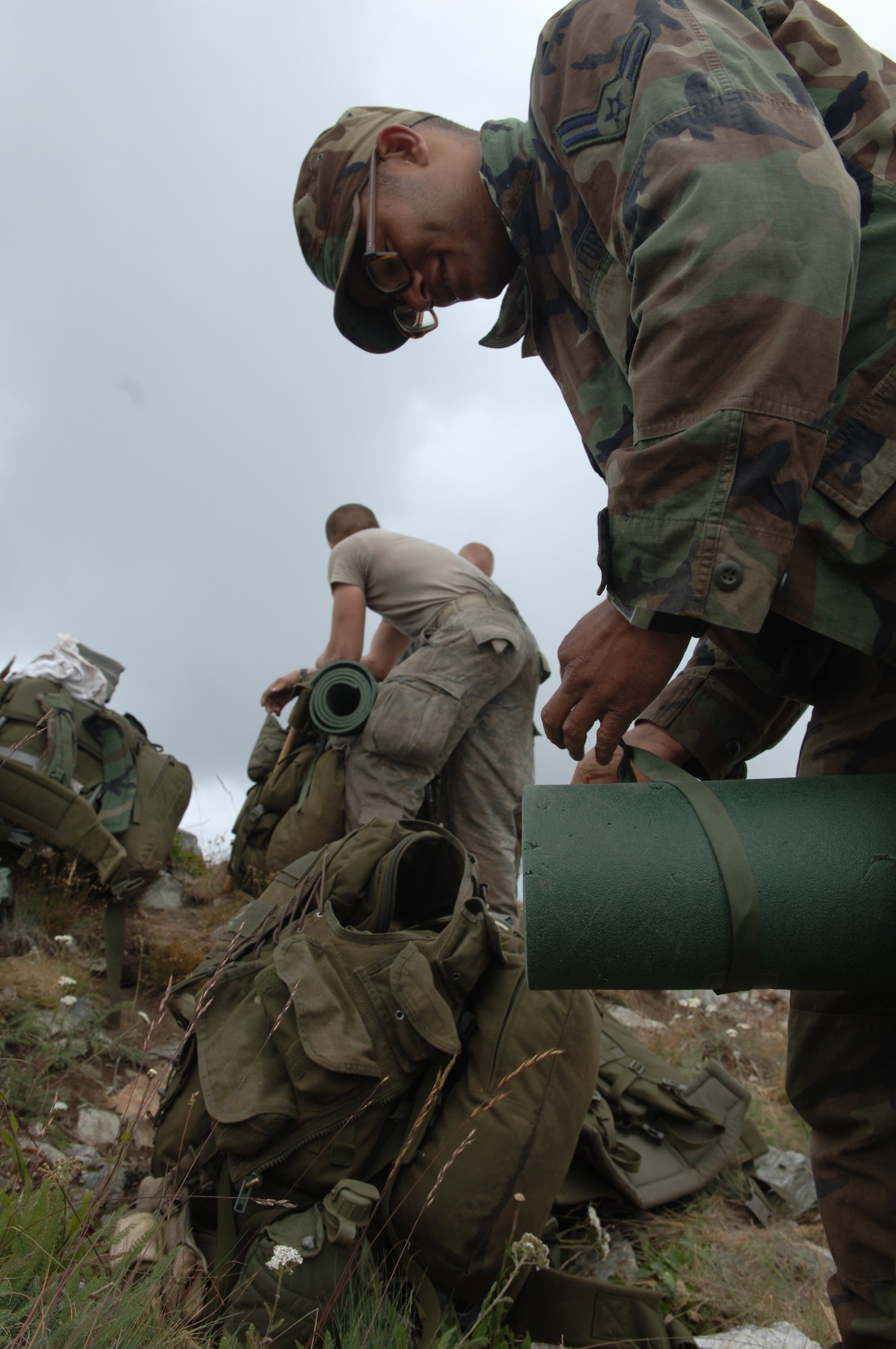 Survival, Evasion, Resistance and Escape students pack their gear before hiking down a mountain during the Mobile phase of SERE training. (U.S. Air Force photo/Senior Airman Jocelyn Guthrie)