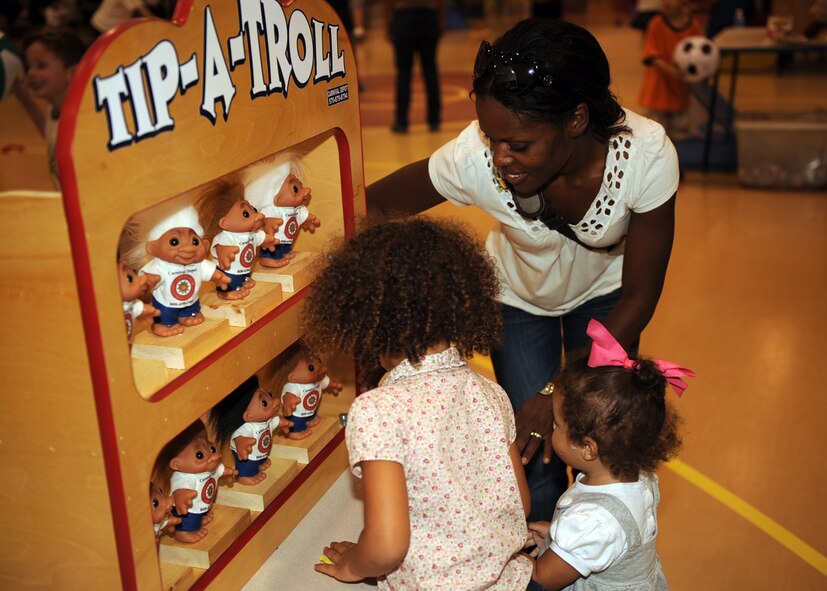 Tanya Lewis, wife of Capt. Gabriel Lewis, 335th Fighter Squadron, and their daughters, Claire and Ella, play tip-a-troll, one of the games offered at the Yellow Ribbon/Worldwide Day of Play event held at the Youth Center on Seymour Johnson Air Force Base, N.C., Sept. 25, 2009. Worldwide Day of Play is held annually to promote fitness and health education for children. (U.S. Air Force/Senior Airman Ciara Wymbs)


