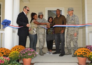 LANGLEY AIR FORCE BASE, Va. -- Maj. Paula Chavis, 1st Inpatient Operations Squadron, and her family cut the ribbon to their new house with the help of Col. Matt Molloy, 1st Fighter Wing commander, here Sep. 30. The Chavez family is the first family to have a new house in the in the Jamestown Village section of Landings at Langley at Bethel Manor. (U.S. Air Force photo/Airman1st Class John Teti)