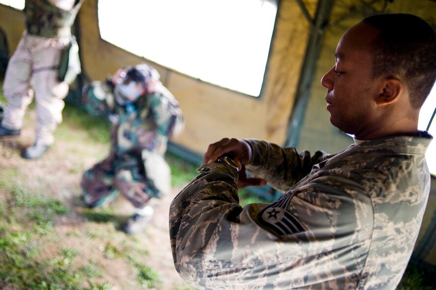 Staff Sergeant Mehtar Sullivan, 62nd Civil Engineer Squadron, monitors the elapsed time on his watch as Airmen don protective gas masks while undergoing Ability to Survive and Operate training here Sept 29 in preparation for the wing's Operational Readiness Inspection in October. (U.S. Air Force Photo/Abner Guzman)