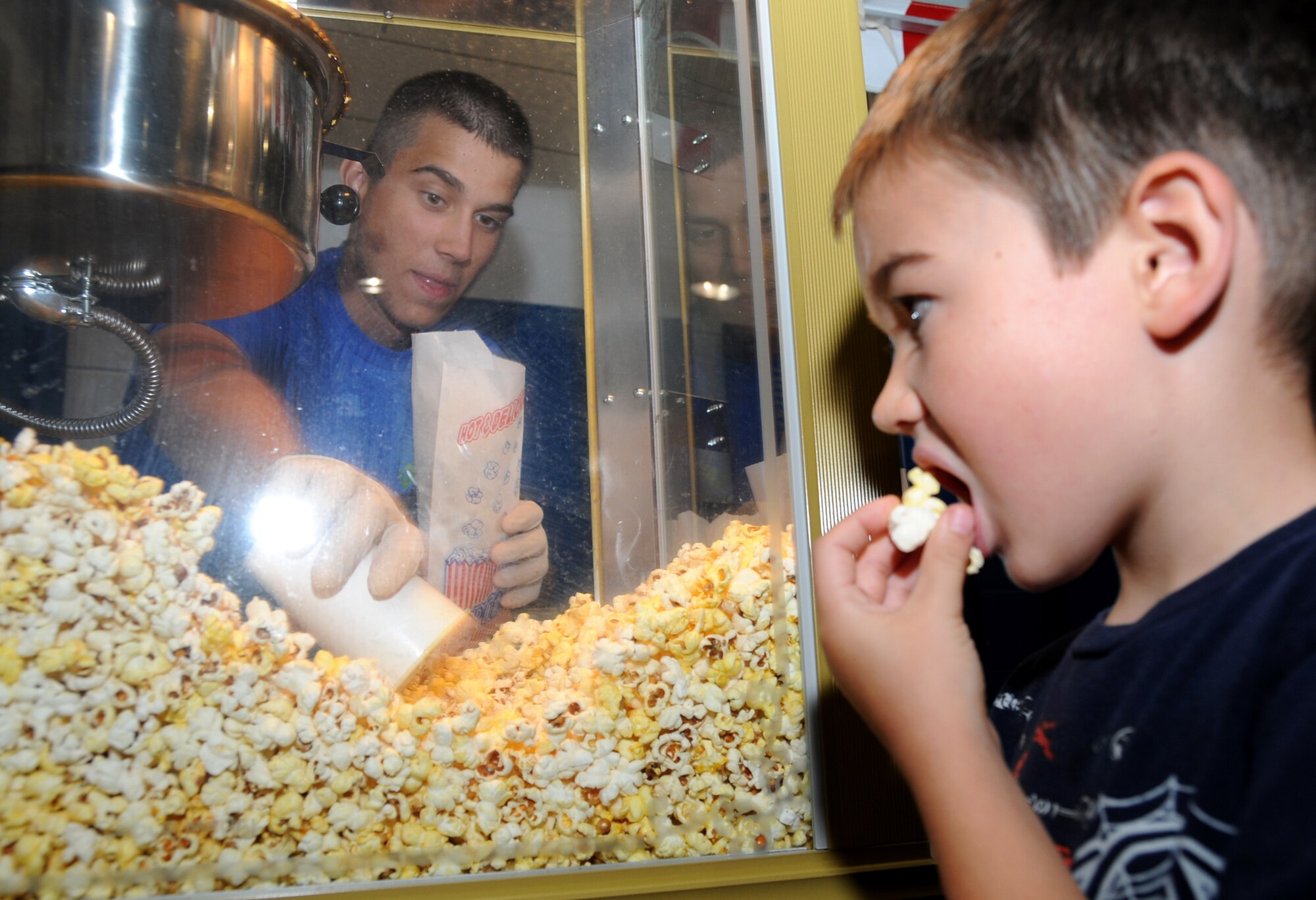 Airman Basic Daniel Kennison, 334th Training Squadron, serves popcorn as 4-year-old Jacob Todd, son of Maj. Larry and Karen Todd, enjoys his treat at Saturday’s World Wide Day of Play co-sponsored by the youth center and airman and family readiness center.  Special guests were children of deployed parents.  Major Todd, 81st Medical Group, is serving a six-month deployment in Afghanistan.   (U.S. Air Force photo by Kemberly Groue)