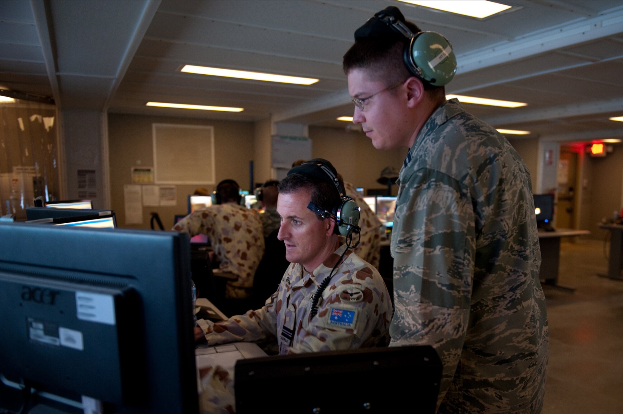 Right, U.S. Air Force Capt. Jeffery Falanga and Royal Australian Air Force Squadron Leader Jason Brown, both 71st Expeditionary Air Control Squadron senior directors, manage and oversee support and combat aircraft into target areas, Sept. 30, in Southwest Asia. The 71 EACS provides round-the-clock air defense and air battle execution of Southwest Asia. (U.S. Air Force Photo/Staff Sgt. Robert Barney/Released)