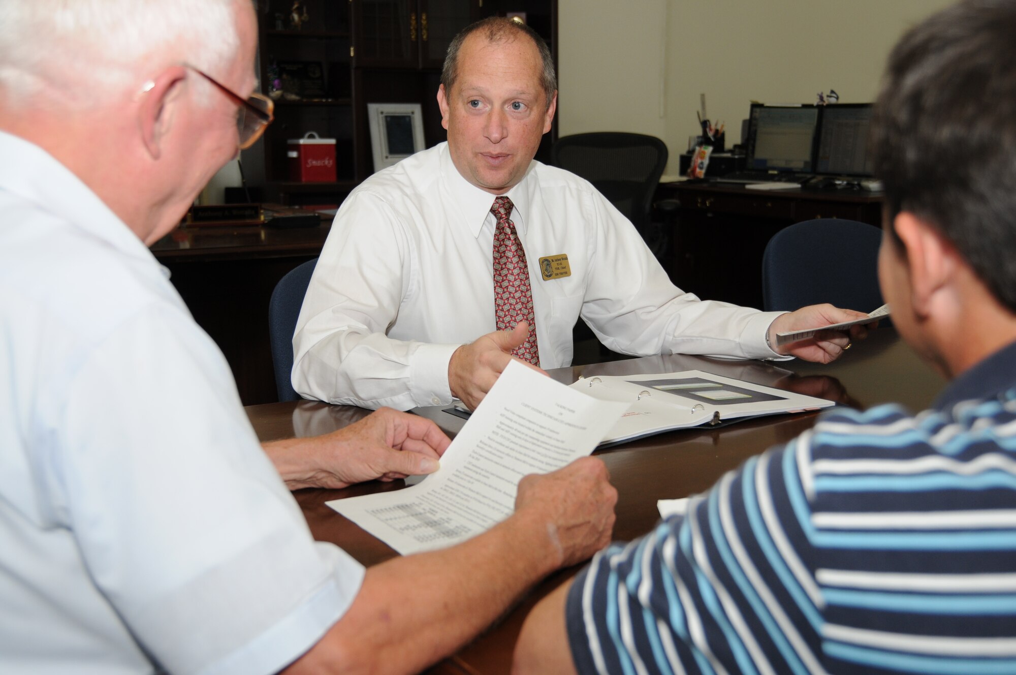 Linus Clark, left, and Steve Proctor, right, discuss the Defense Connect Online collaborative network 7-level course with Mr. Woitalla.  All three work in the 338th TRS.  (U.S. Air Force photo by Kemberly Groue)