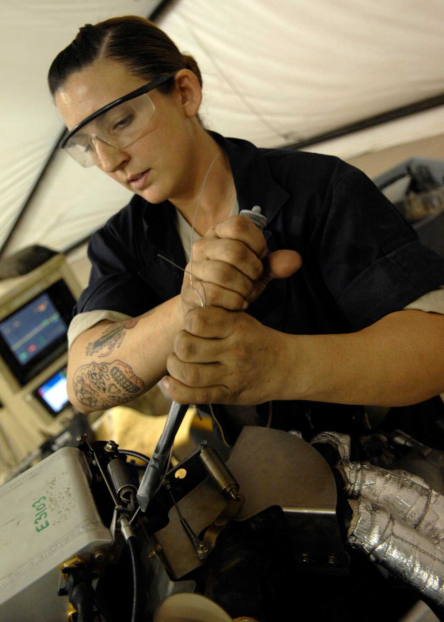 Senior Airman Valerie Santa installs safety wire on an MQ-1 Predator during an engine rebuild while performing maintenance here, Sept. 23, 2009. Airman Santa is a crew chief for the 62nd Expeditionary Reconnaissance Squadron from Creech Air Force Base, Nev. and hails from Apple Valley, Calif. (U.S. Air Force photo/Senior Airman Timothy Taylor)