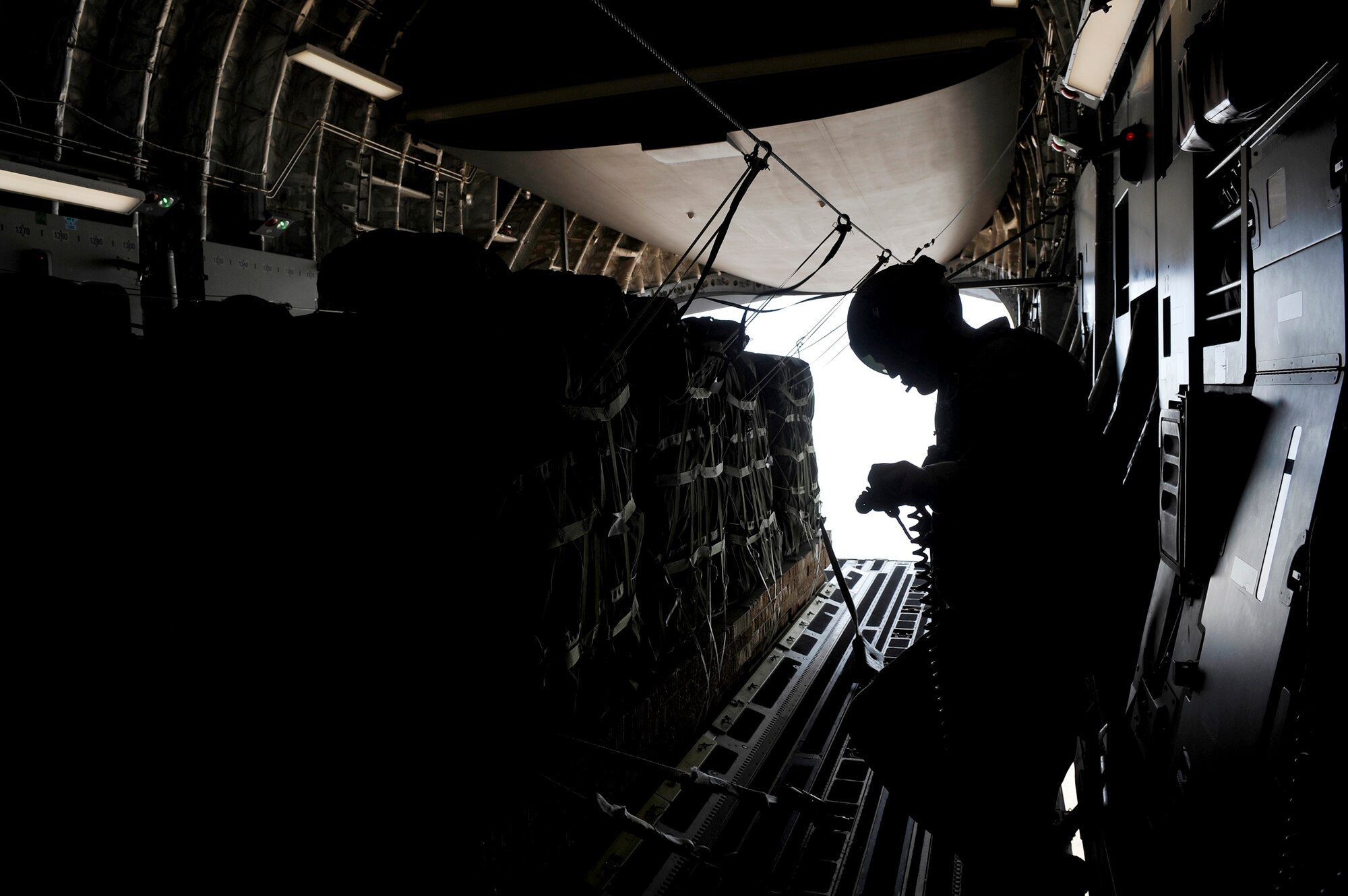 A loadmaster from the 816th Expeditionary Airlift Squadron waits for the signal to release container delivery system bundles from a C-17 Globemaster III Sept. 23, 2009, over Afghanistan. The bundles, full of supplies for Marines, will be dropped to a base in Afghanistan. (U.S. Air Force photo/Staff Sgt. Angelita Lawrence) 
