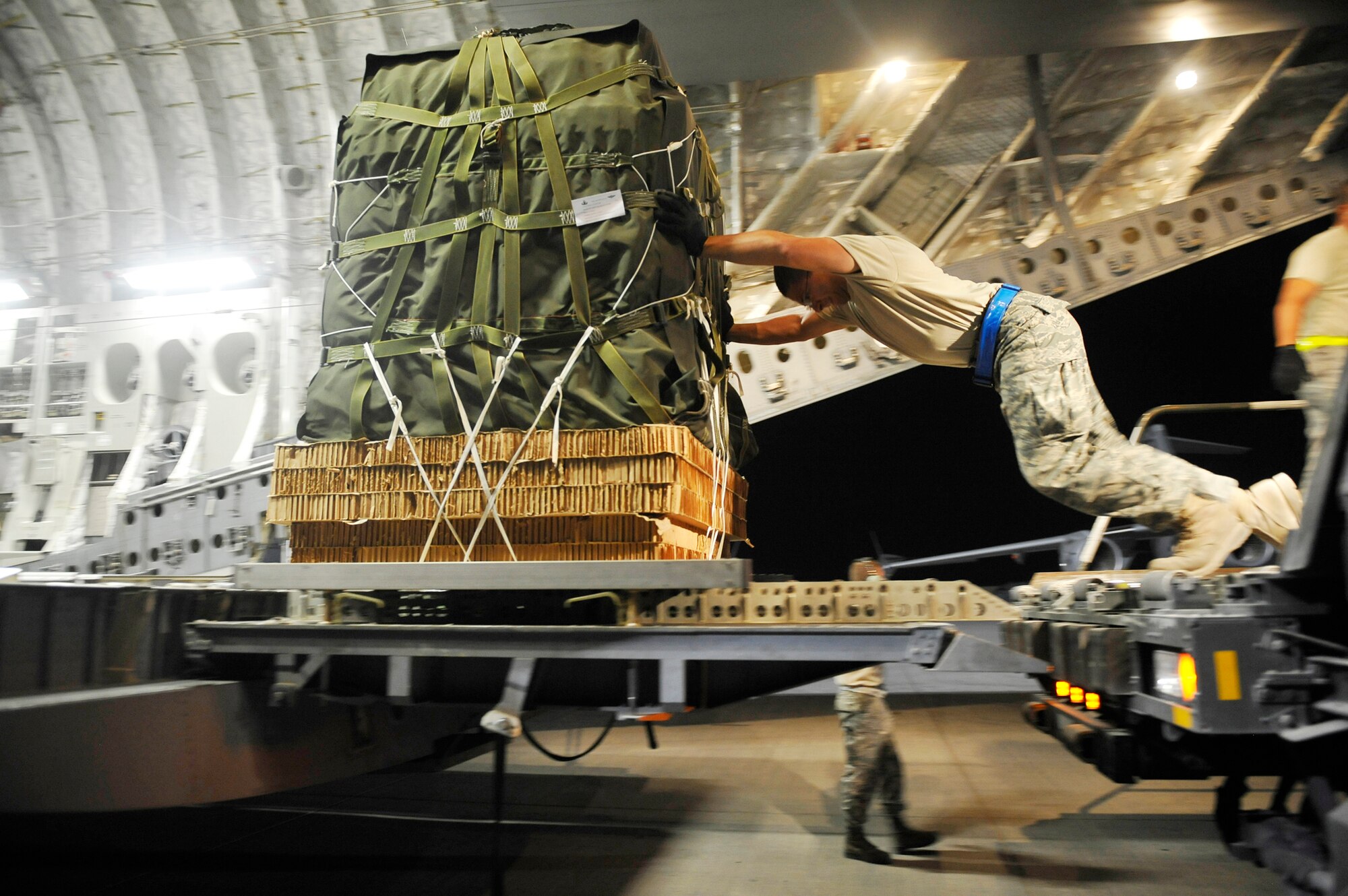 Airman 1st Class Andrew Dasilva loads a C-17 Globemaster III with container delivery system bundles Sept. 23, 2009, at an air base in Southwest Asia. The bundles, full of supplies for Marines, will be dropped to a base in Afghanistan. Airman Dasilva is an 8th Expeditionary Aircraft Maintenance Squadron ramp service specialist. (U.S. Air Force photo/Staff Sgt. Angelita Lawrence) 