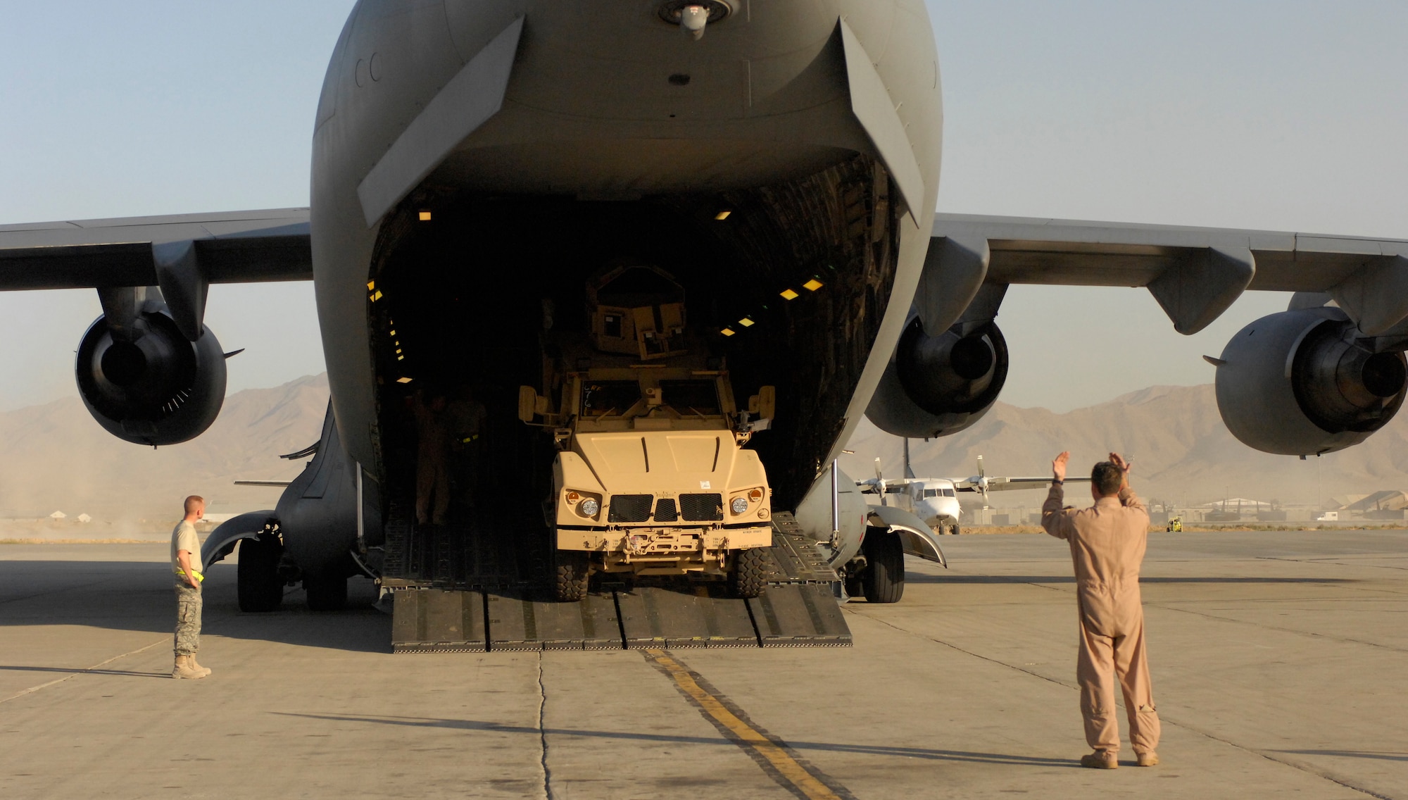 A C-17 Globemaster III loadmaster spots the driver of a mine-resistant, ambush-protected all-terrain vehicle, or M-ATV as he drives it off the aircraft at Bagram Air Field, Afghanistan, on Oct. 1, 2009. The M-ATV's are the first of their kind in Afghanistan and support small-unit combat operations in highly restricted rural, mountainous and urban environments that include mounted patrols, reconnaissance, security, convoy protection, communications, command and control and combat service support. Transporting a load of M-ATVs by U.S. Air Force aircraft can be accomplished in a day, where sealift would require approximately 26 days.  An order for more than 6,600 of the M-ATVs are expected to be fielded over the next year. Three M-ATVs were loaded onto a C-17 Globemaster III and four onto a C-5 Galaxy at Air Mobility Command's Charleston Air Force Base, S.C., on Sept. 29 and flown to Afghanistan.  The M-ATV is designed to replace the up-armored Humvee in Afghanistan. The M-ATV will carry up to five personnel: four plus a gunner. The C-17 is from McChord Air Force Base, Wash. and was operated by a crew from Charleston AFB, S.C. (U.S. Air Force Photo/Senior Airman Susan Tracy)