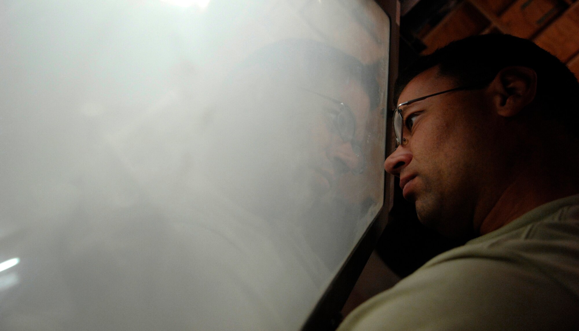 Staff Sgt. Mark Samaniego peers through a protective window as he sand-blasts a part for an MQ-1 Predator during an engine rebuild here, Sept. 23, 2009. Predators support ground troops and intelligence collection with its long airborne loiter time and ability to deploy the AGM-114 Hellfire missle. Sergeant Samaniego is a crew chief with the 62 Expeditionary Reconnaisance Squadron from Creech Air Force Base, Nev. (U.S. Air Force photo/Senior Airman Timothy Taylor)