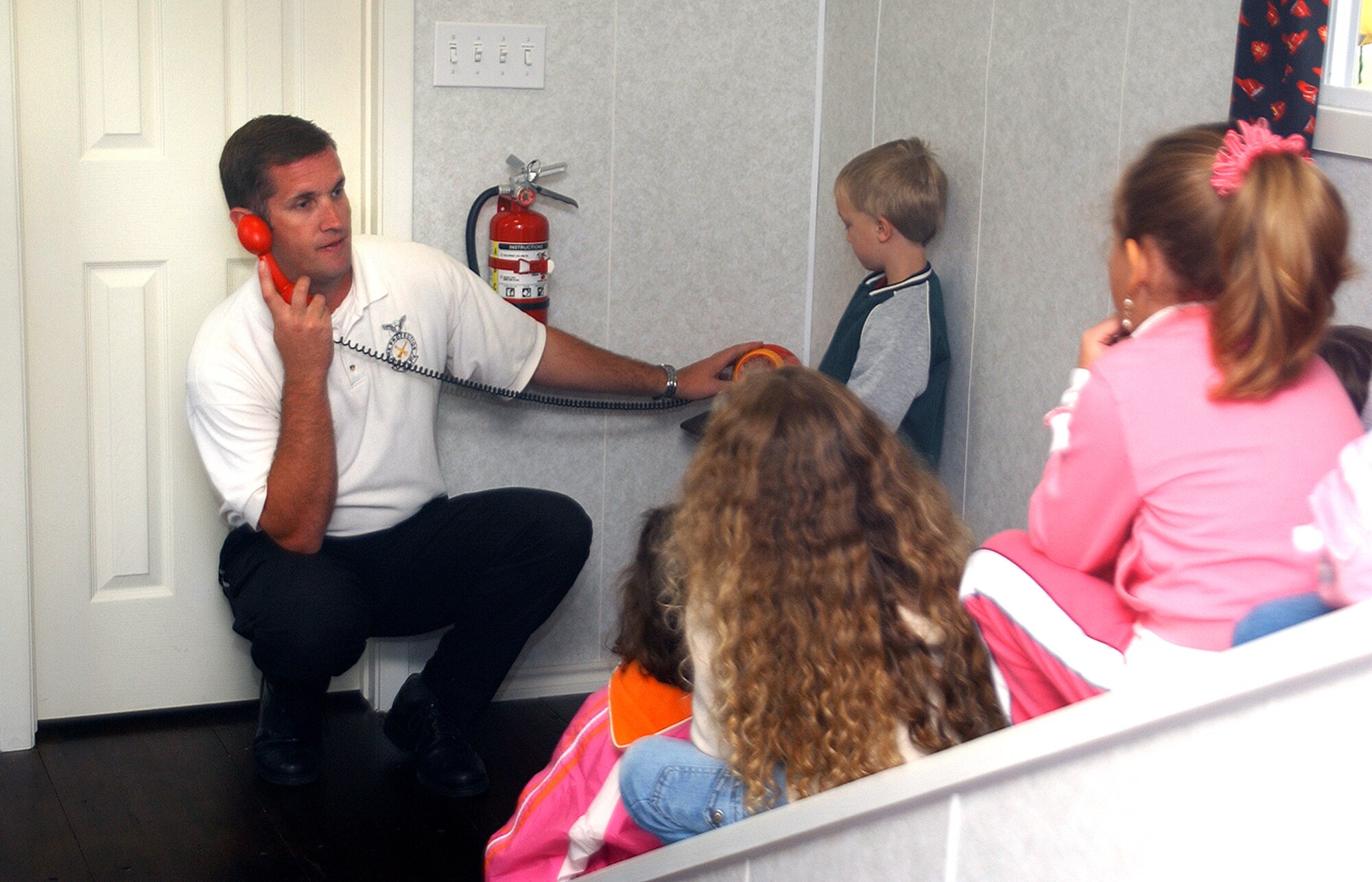 Hal McLelland, 82nd Civil Engineering Squadron fire inspector, teaches local children about fire safety and prevention using the fire prevention education trailer. The trailer will be on display at the BX Oct. 3. (U.S. Air Force photo/ 82nd CES/CEF)