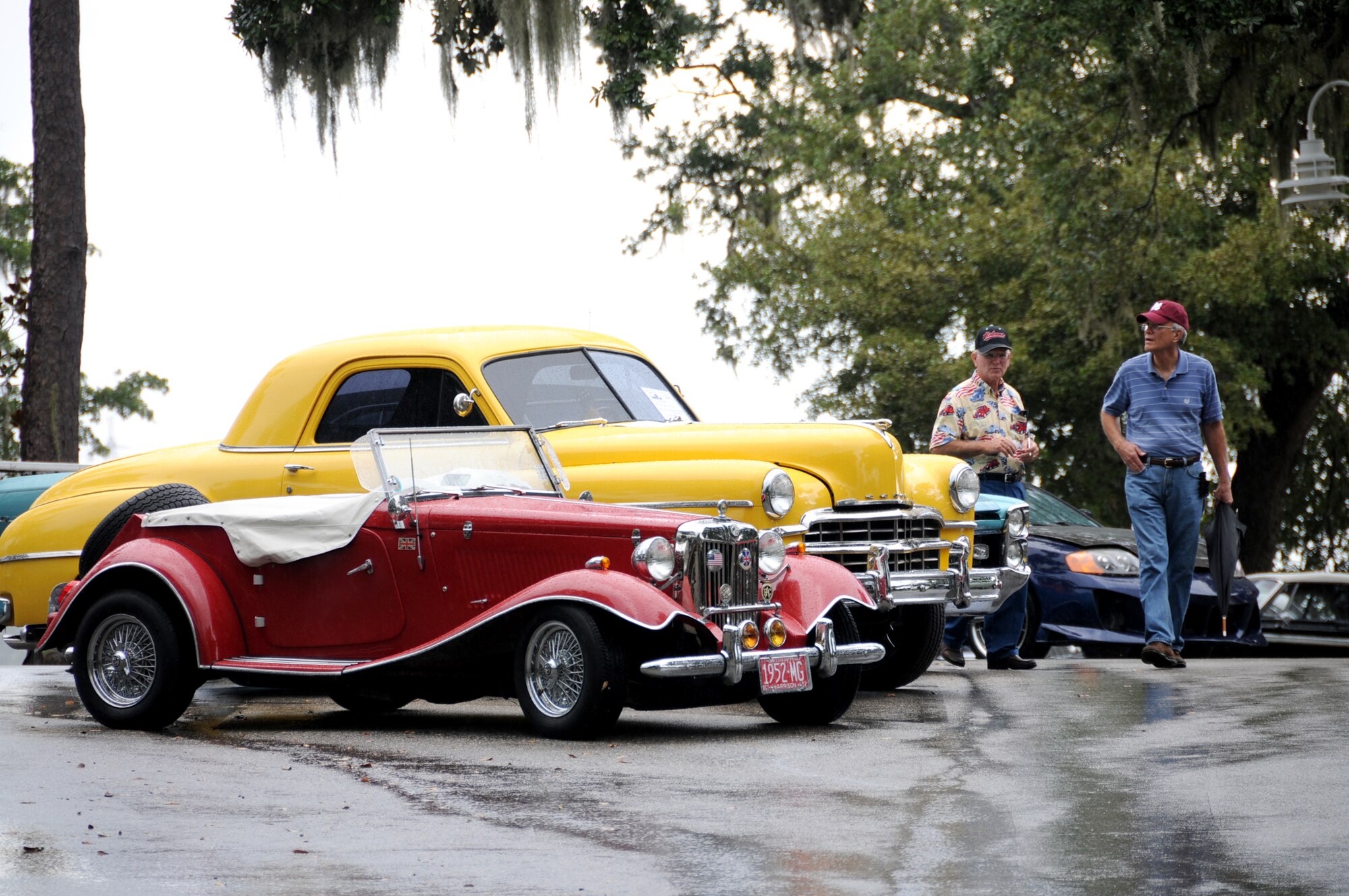 Jerry Sessions and Chuck Rockwell of Grand Bay, Ala., conduct an unofficial judging for participant rating as a downpour moves in Saturday for Cruisin’ Keesler at marina Park.  Cars, trucks, motorcycles and street rods competed for cash prizes in a variety of categories.  Sponsors included Budweiser, Keesler Federal Credit Union, GEICO, Gulfport Dragway and Mandal Automotive.  (U.S. Air Force photo by Kemberly Groue)