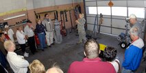 MINOT AIR FORCE BASE, N.D. -- Senior Airman Emily Walker, 5th Civil Engineer Squadron explosive ordinance disposal technician, explains the different types of explosive devices and ways of disarming bombs to members of the League of Cities at the EOD unit Sept. 25 here. Group tours such as these continue the growing friendship between Minot AFB and its surrounding communities all across the state. (U.S. Air Force photo by Airman 1st Class Benjamin Stratton)