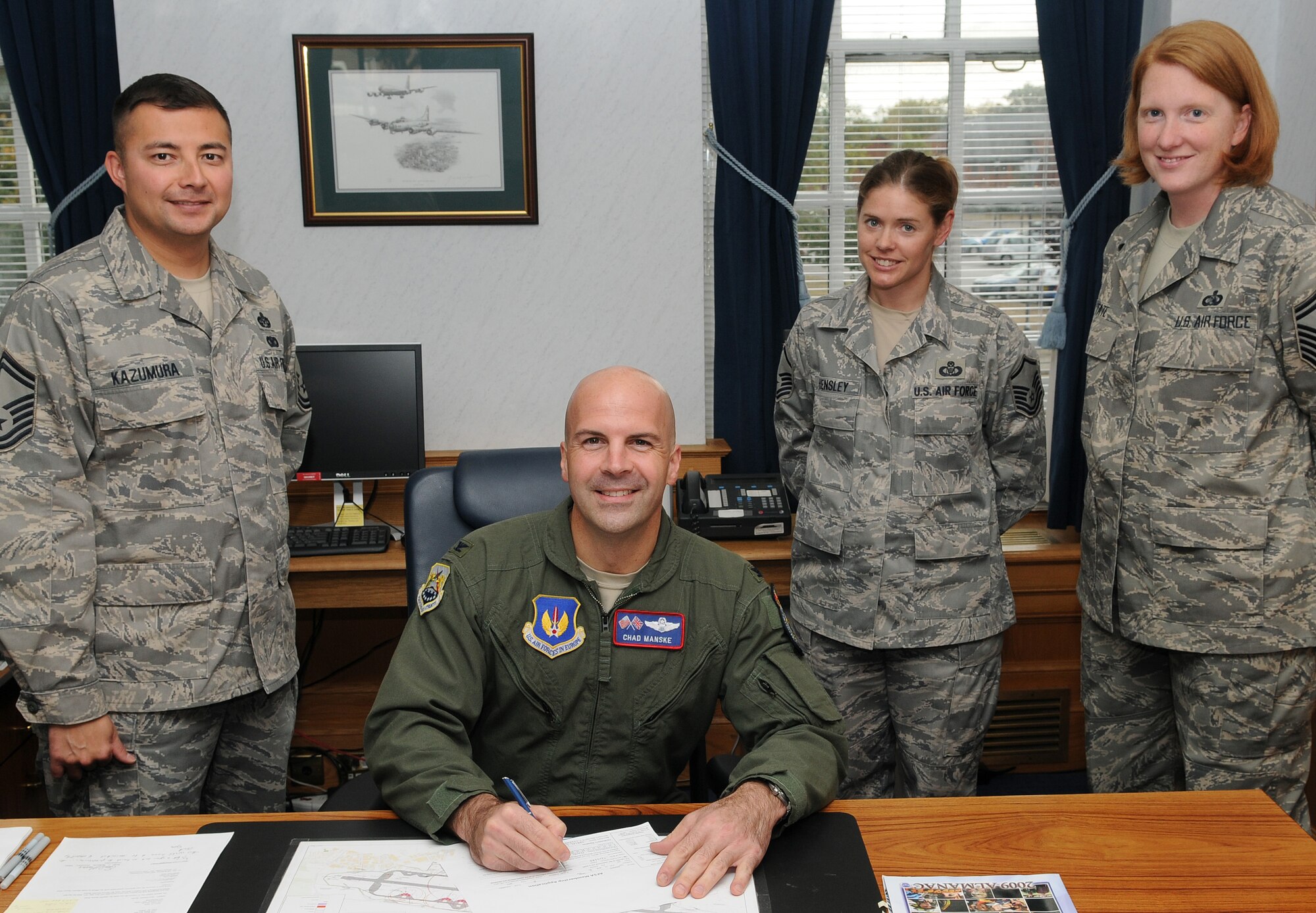 RAF MILDENHALL, England -- Col. Chad Manske, 100th Air Refueling Wing commander (seated), signs an Air Force Sergeant's Association membership application at the 100th ARW headquarters here Oct. 1. Colonel Manske renewed his current membership for another three years to become an active member of RAF Mildenhall's AFSA Chapter 1670. He was accompanied by (left to right) Senior Master Sgt. Daniel Kazamura, chapter president, and chapter executive members Master Sgt. Jessica Hensley and Senior Master Sgt. Jennifer Tate. (U.S. Air Force photo/Senior Airman Thomas Trower)