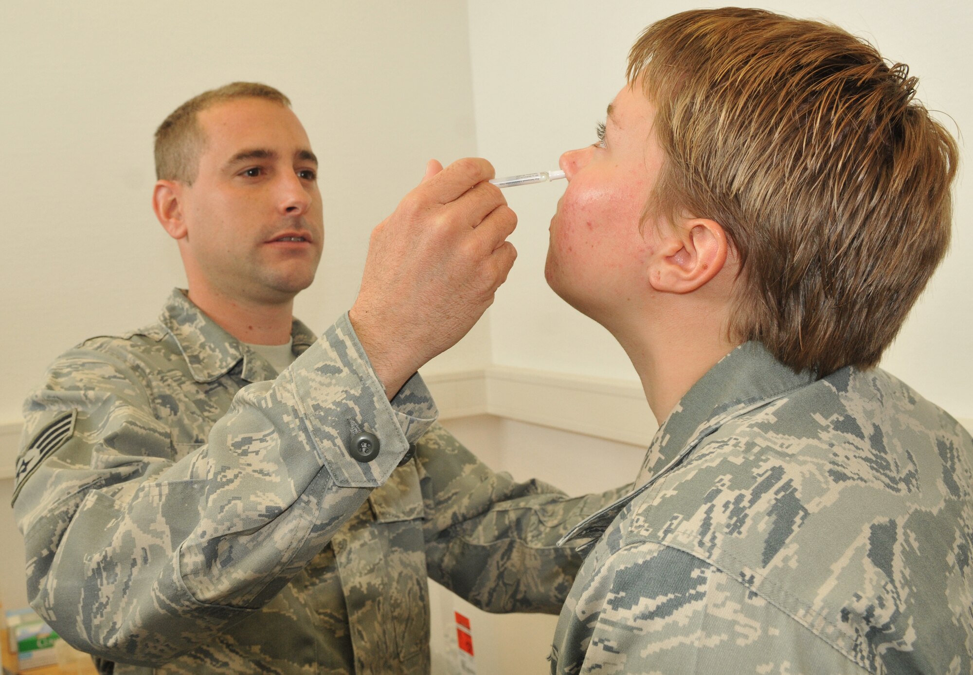 SPANGDAHLEM AIR BASE, Germany -- Staff Sgt. Brian Schmit, 52nd Medical Operations Squadron, gives a flu mist vaccination to Airman 1st Class Samantha Draves, 52nd Civil Engineer Squadron, Sept. 29 at a mass flu vaccination at building 103. The vaccines provided to Sabers included immunization for three common flu strains. The H1N1 influenza strain was not among those; however, a vaccine for this is expected to seen in the near future.  For people who didn’t get the flu vaccination, immunizations will be given again 7 a.m. to 5 p.m. Oct 6-7 in building 103.  (U.S. Air Force photo/Airman 1st Class Nick Wilson)