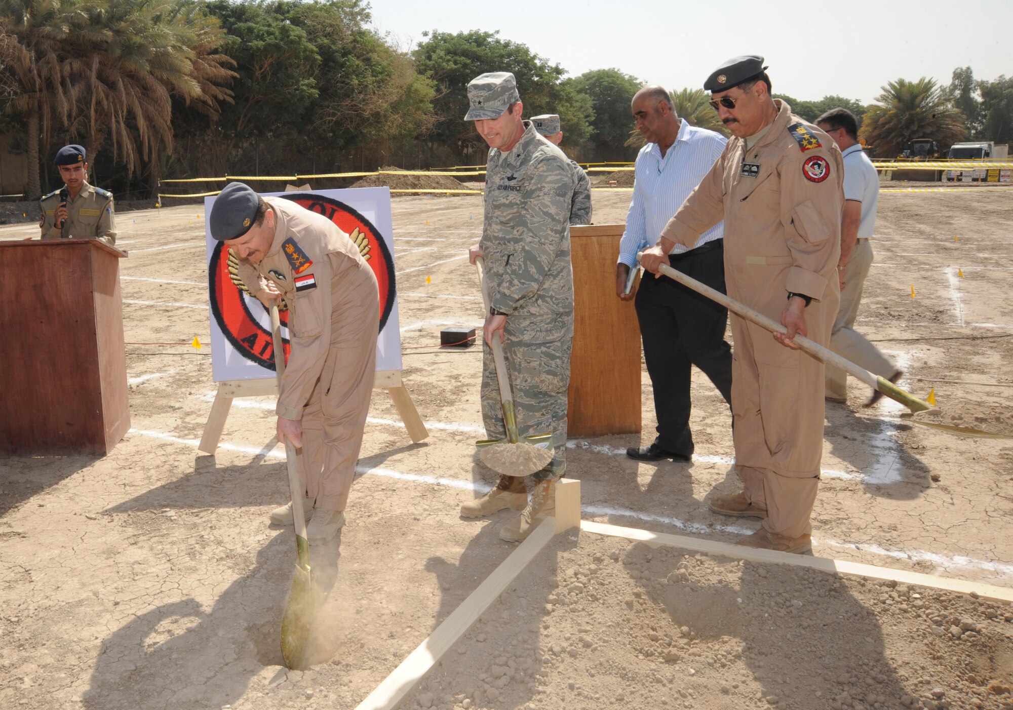HAWK BASE, Iraq -- Iraqi Air Force Commander Staff Lt. Gen. Anwar dumps the first shovel full of dirt to bury a time capsule as U.S. Air Force Maj. Gen. Robert Kane, Iraqi Training and Advisory Mission - Air Force director, and Staff Brig. Gen. Wamidh, Iraqi Air Force director of operations look on during the Iraqi Air Operations Center ground breaking ceremony here Sept. 30, 2009. The time capsule contains candid photographs of Iraqi and U.S. AOC personnel and will be buried under the foundation of the new Iraqi AOC.  The facility will play a vital role in the growth and future success of the Iraqi air force and maintaining a secure, stable, and sovereign Iraq. (U.S. Air Force photo/Tech. Sgt. Johnny L. Saldivar)