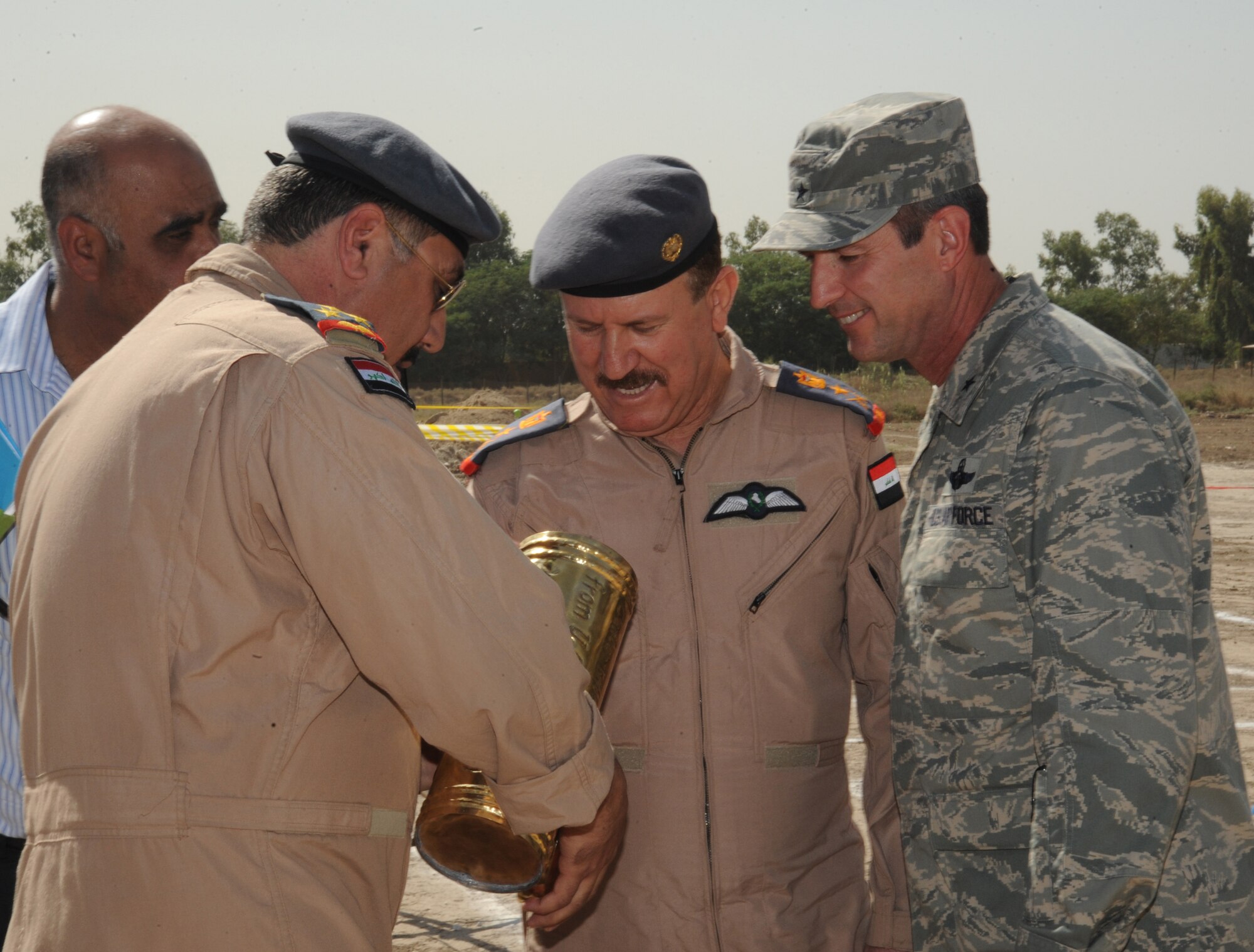 HAWK BASE, Iraq -- Iraqi Air Force Director of Operations, Staff Brig. Gen. Wamidh (left), Staff Lt. Gen. Anwar, Iraqi Air Force Commander (center) and U.S. Air Force Maj. Gen. Robert Kane, Iraqi Training and Advisory Mission - Air Force director, look at the contents of a time capsule during the Iraqi Air Operations Center ground breaking ceremony here Sept. 30, 2009. The time capsule contains candid photographs of Iraqi and U.S. AOC personnel and will be buried under the foundation of the new Iraqi AOC.  The facility will play a vital role in the growth and future success of the Iraqi air force and maintaining a secure, stable, and sovereign Iraq. (U.S. Air Force photo/Tech. Sgt. Johnny L. Saldivar)
