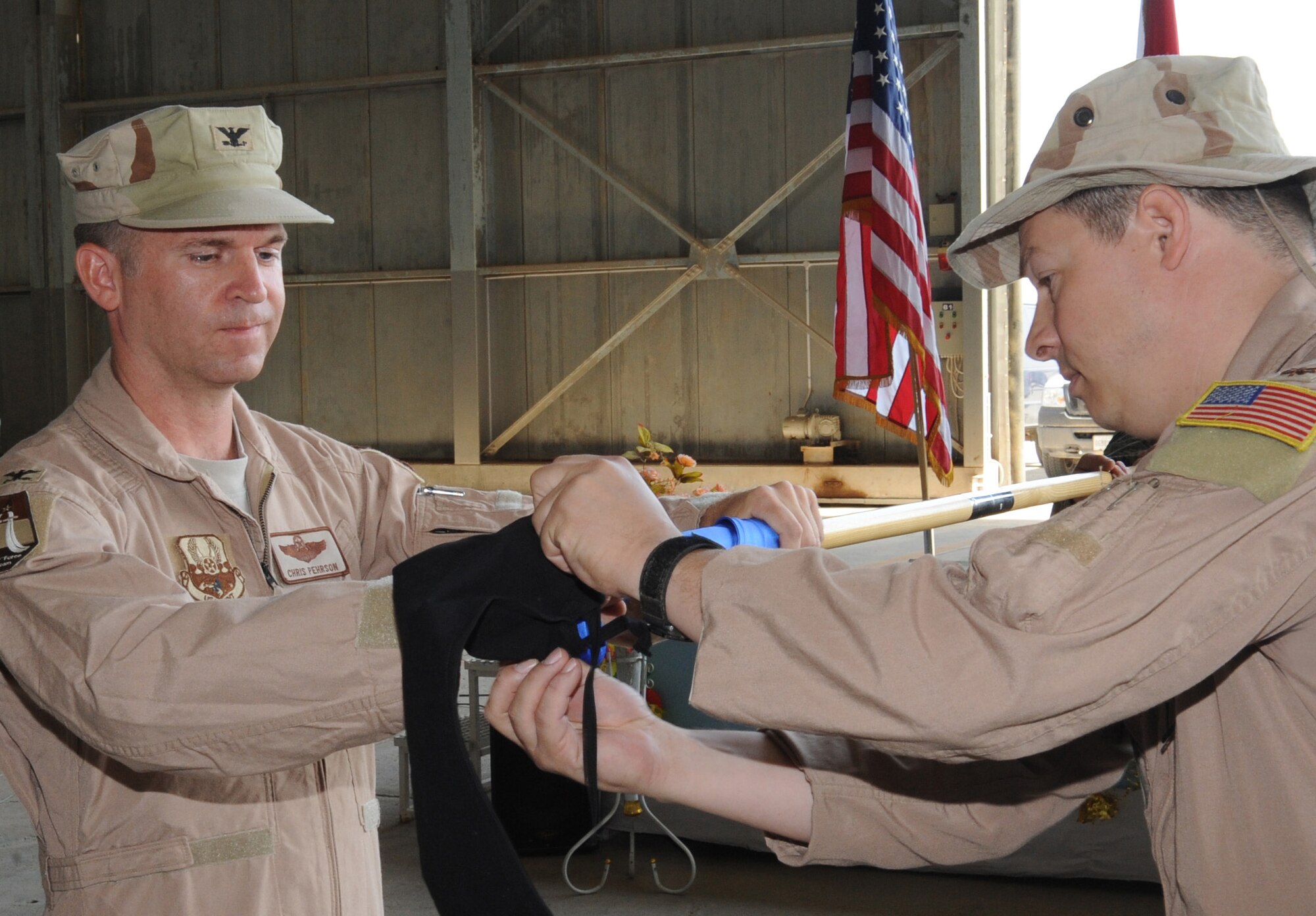 NEW AL MATHANA AIR BASE, Iraq -- Col. Christopher Pehrson (left), 321st Air Expeditionary Advisory Group commander, and Maj. Scott Volk, outgoing 321st Air Expeditionary Advisory Squadron commander, case the squadron's guidon symbolizing the end of the squadron's mission here Sept. 29, 2009. The 321st AEAS stood up at NAMAB with the mission to effectively help facilitate the Iraqi air force's reconstruction and train them to become self-sufficient in the maintenance, flying and operation of the C-130. (U.S. Air Force photo/Tech. Sgt. Johnny L. Saldivar)
