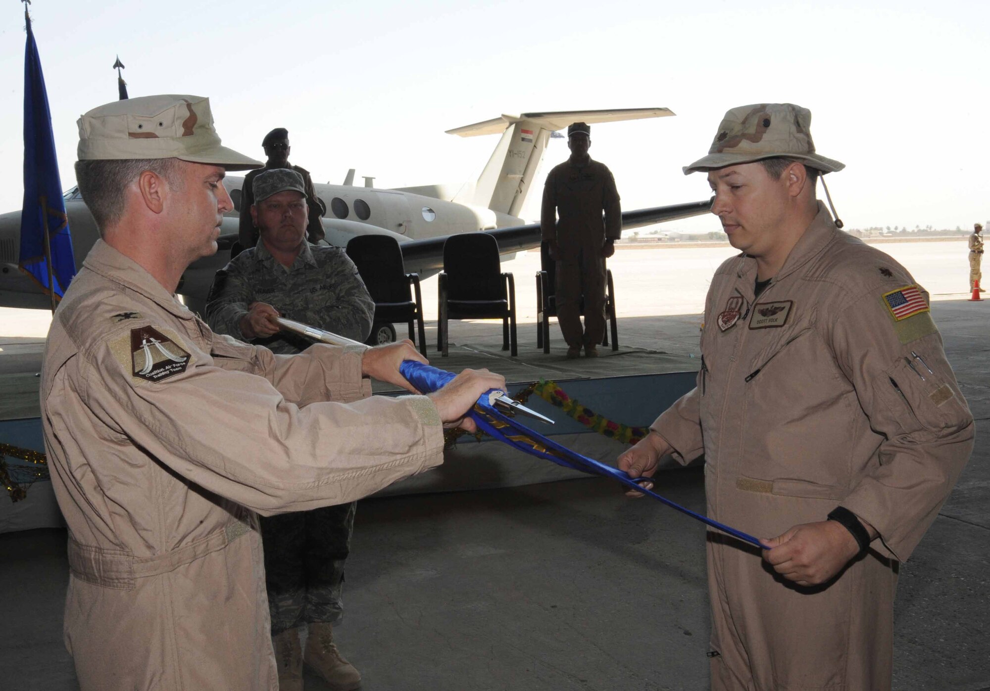 NEW AL MATHANA AIR BASE, Iraq -- Col. Christopher Pehrson (left), 321st Air Expeditionary Advisory Group commander, and Maj. Scott Volk, outgoing 321st Air Expeditionary Advisory Squadron commander, furl the squadron's guidon symbolizing the end of the squadron's mission here Sept. 29, 2009. The 321st AEAS stood up at NAMAB with the mission to effectively help facilitate the Iraqi air force's reconstruction and train them to become self-sufficient in the maintenance, flying and operation of the C-130. (U.S. Air Force photo/Tech. Sgt. Johnny L. Saldivar)
