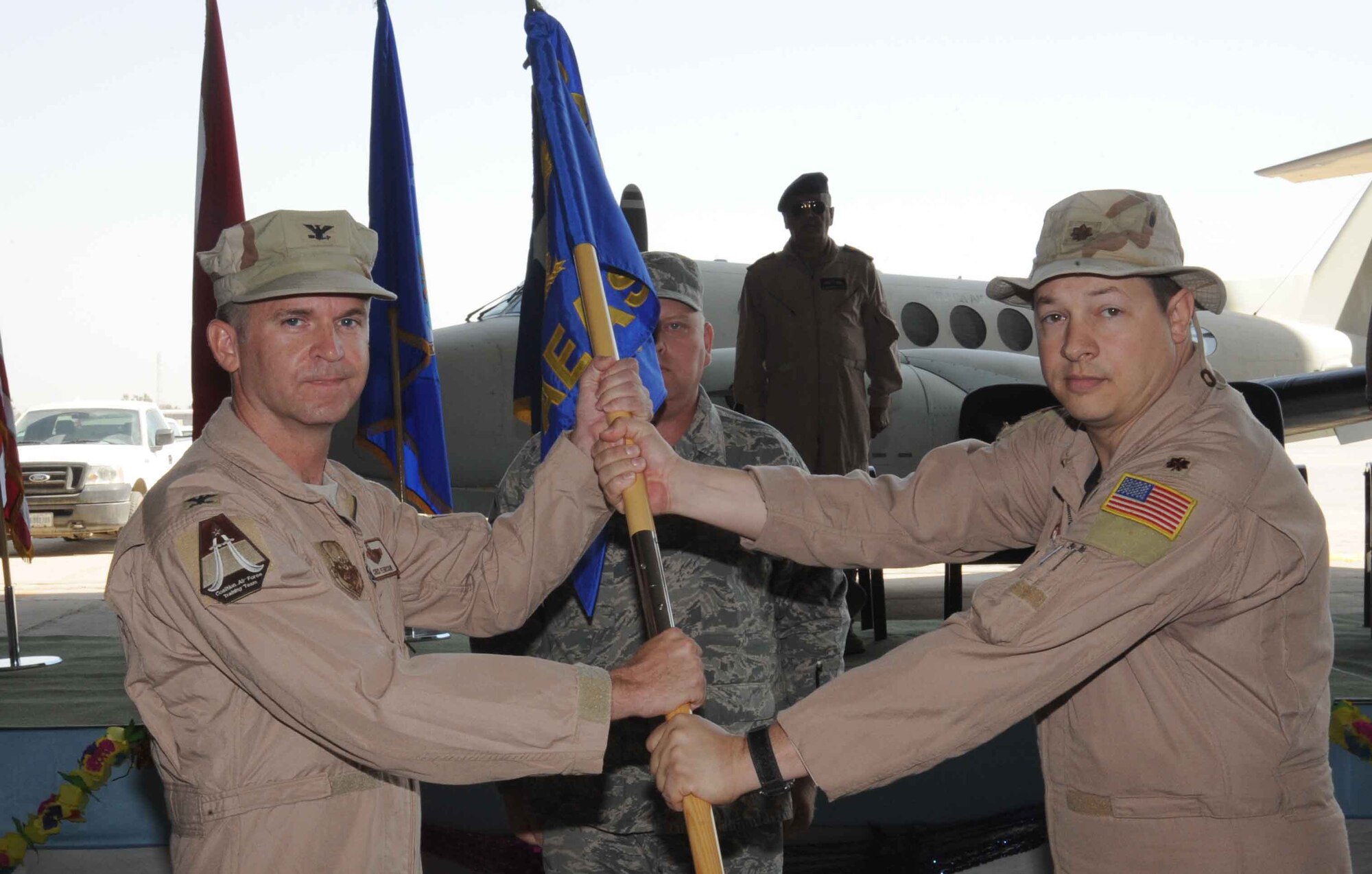NEW AL MATHANA AIR BASE, Iraq -- Col. Christopher Pehrson (left), 321st Air Expeditionary Advisory Group commander, and Maj. Scott Volk, outgoing 321st Air Expeditionary Advisory Squadron commander, prepare to furl the squadron's guidon, symbolizing the end of the squadron's mission here Sept. 29, 2009. The 321st AEAS stood up at NAMAB with the mission to effectively help facilitate the Iraqi air force's reconstruction and train them to become self-sufficient in the maintenance, flying and operation of the C-130. (U.S. Air Force photo/Tech. Sgt. Johnny L. Saldivar)
