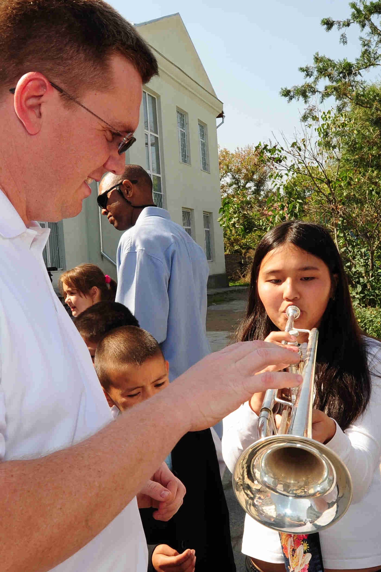 BISHKEK, Kyrgyzstan -- Staff Sgt. Jeffrey Reich, U.S. Air Forces Central Command 'Falcon' Band trumpet player, shares his instrument with a Bishkek Boarding School for the Blind and Visually-Impaired Children student following a performance at the school, Sept. 28, 2009. Sergeant Reich and the 'Falcon' Band members are stationed at a base in Southwest Asia and are deployed from Offutt Air Force Base, Neb. (U.S. Air Force photo/Senior Airman Steele C. G. Britton)