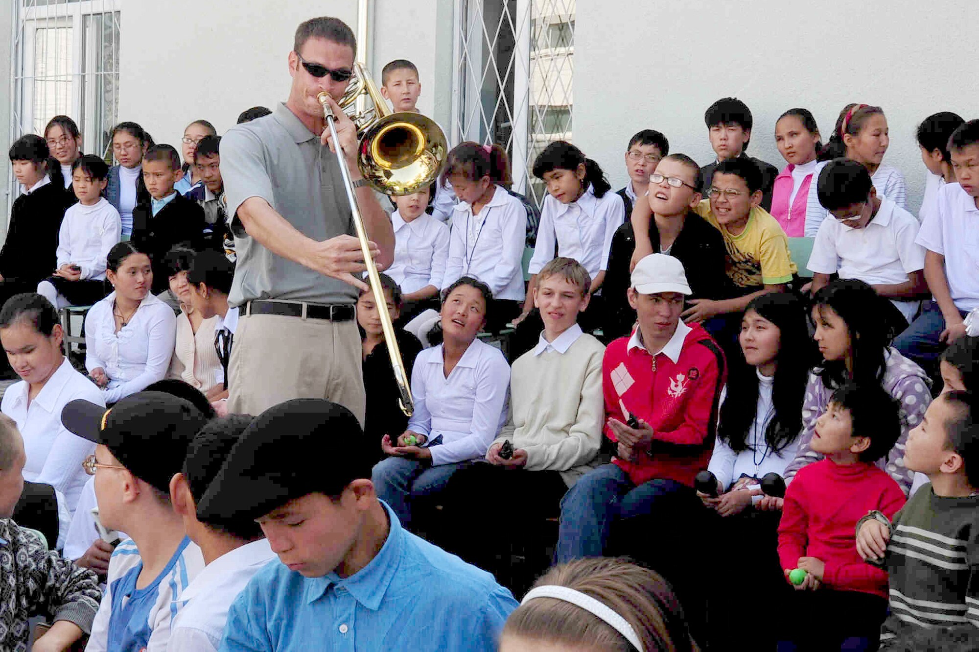 BISHKEK, Kyrgyzstan -- Staff Sgt. Matthew Erickson, U.S. Air Forces Central Command 'Falcon' Band bass trombone player, gets close with  Bishkek Boarding School for the Blind and Visually-Impaired Children during a performance, Sept. 28, 2009. Sergeant Erickson and the 'Falcon' Band members are stationed at a base in Southwest Asia and are deployed from Offutt Air Force Base, Neb. (U.S. Air Force photo/Senior Airman Steele C. G. Britton)