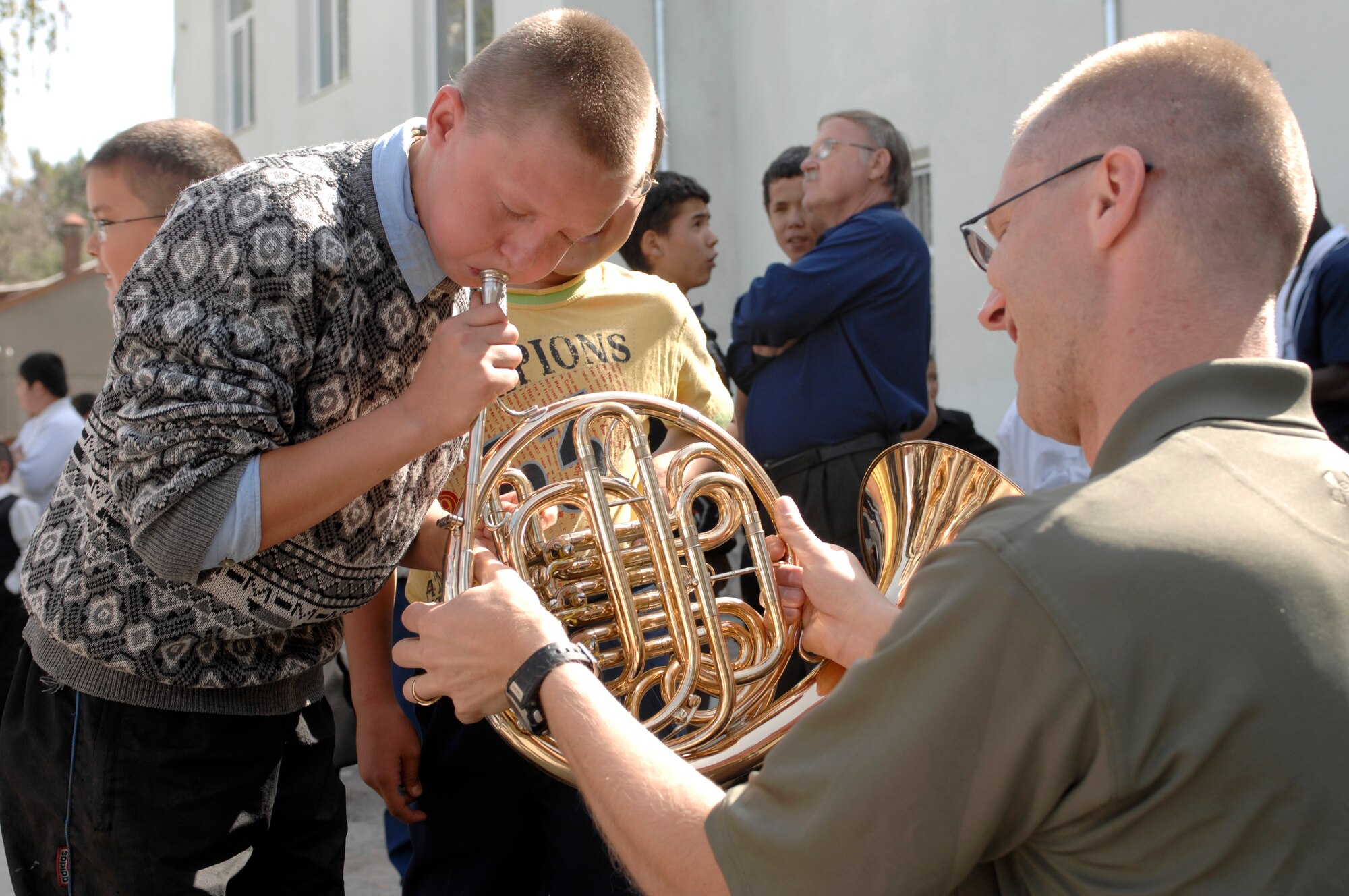 BISHKEK, Kyrgyzstan -- Tech. Sgt. Patrick Heseltine, U.S. Air Forces Central Command 'Falcon' Band French horn player, lets a Bishkek Boarding School for the Blind and Visually-Impaired Children student try his instrument after a performance at the school, Sept. 28, 2009. Sergeant Heseltine and the 'Falcon' Band members are stationed at a base in Southwest Asia and are deployed from Offutt Air Force Base, Neb. (U.S. Air Force photo/Senior Master Sgt. Andrew E. Lynch)