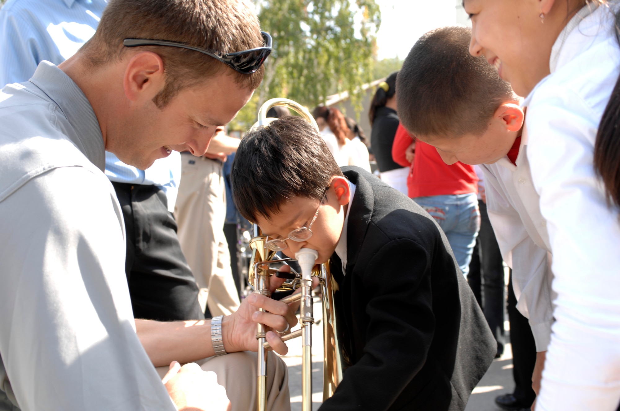 BISHKEK, Kyrgyzstan -- Staff Sgt. Matthew Erickson, U.S. Air Forces Central Command 'Falcon' Band bass trombone player, helps a  Bishkek Boarding School for the Blind and Visually-Impaired Children student play the trombone following a performance at the school, Sept. 28, 2009. Sergeant Erickson and the 'Falcon' Band members are stationed at a base in Southwest Asia and are deployed from Offutt Air Force Base, Neb. (U.S. Air Force photo/Senior Master Sgt. Andrew E. Lynch)