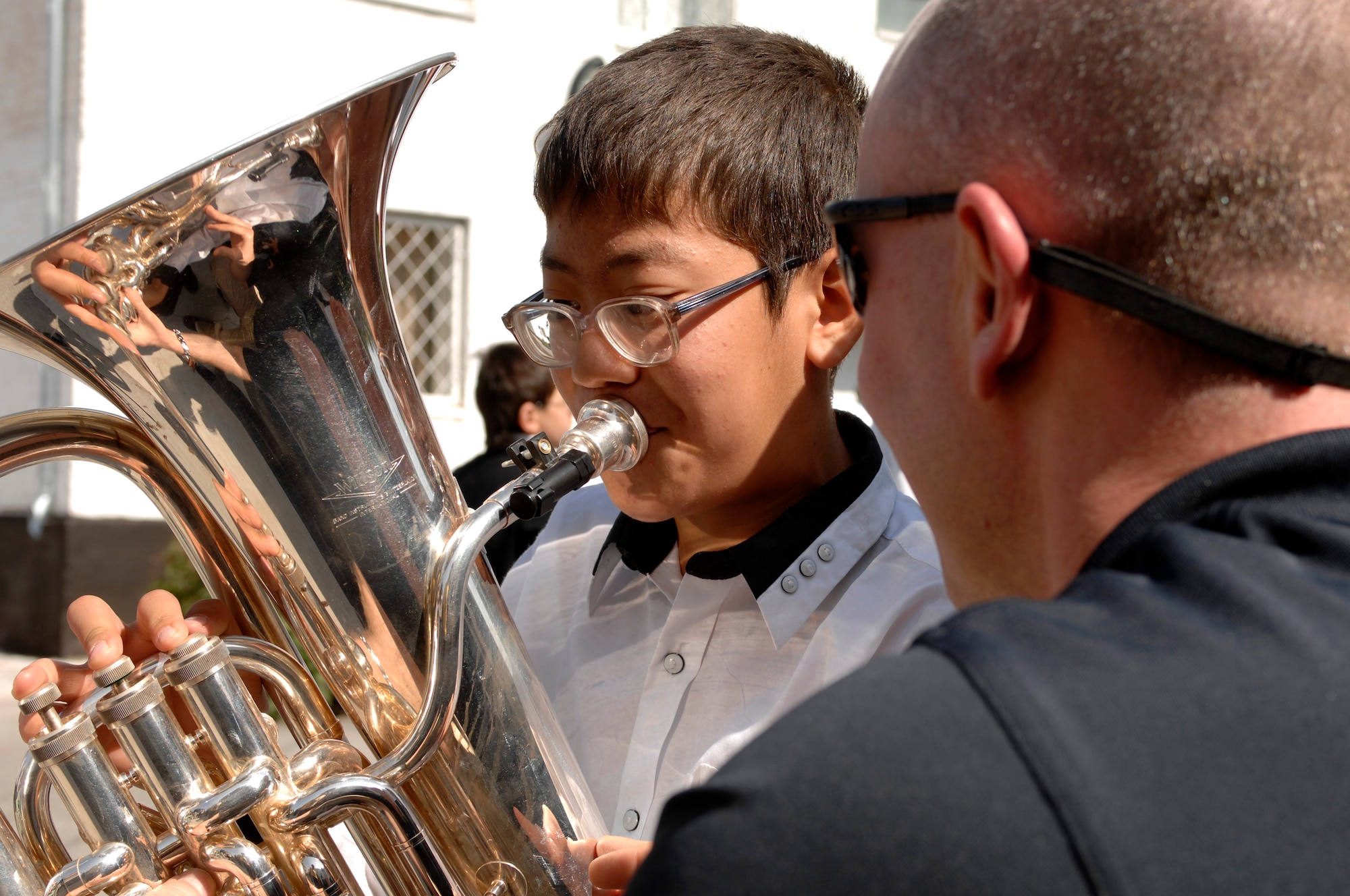 BISHKEK, Kyrgyzstan -- Tech. Sgt. Matthew Dunsmore, U.S. Air Forces Central Command 'Falcon' Band euphonium player, shares his instrument with a  Bishkek Boarding School for the Blind and Visually-Impaired Children student following a performance at the school, Sept. 28, 2009. Sergeant Dunsmore and the 'Falcon' Band members are stationed at a base in Southwest Asia and are deployed from Offutt Air Force Base, Neb.(U.S. Air Force photo/Senior Master Sgt. Andrew E. Lynch)