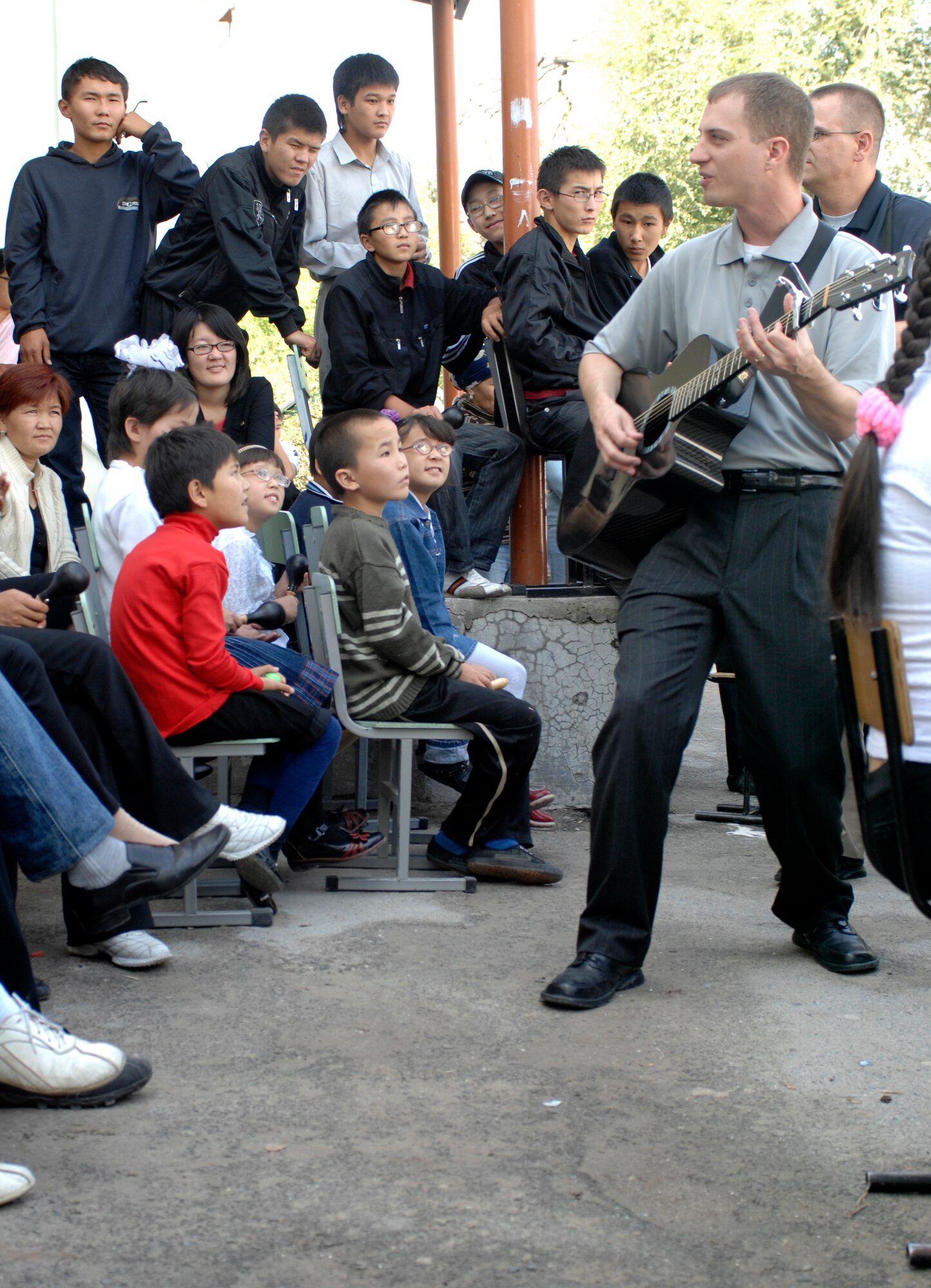 BISHKEK, Kyrgyzstan -- Staff Sgt. Clinton Whitney, U.S. Air Forces Central Command 'Falcon' Band vocalist, walks through the audience at the Bishkek Boarding School for the Blind and Visually-Impaired Children during a performance, Sept. 28, 2009. Sergeant Whitney and the 'Falcon' Band members are stationed at a base in Southwest Asia and are deployed from Offutt Air Force Base, Neb. (U.S. Air Force photo/Senior Master Sgt. Andrew E. Lynch)
