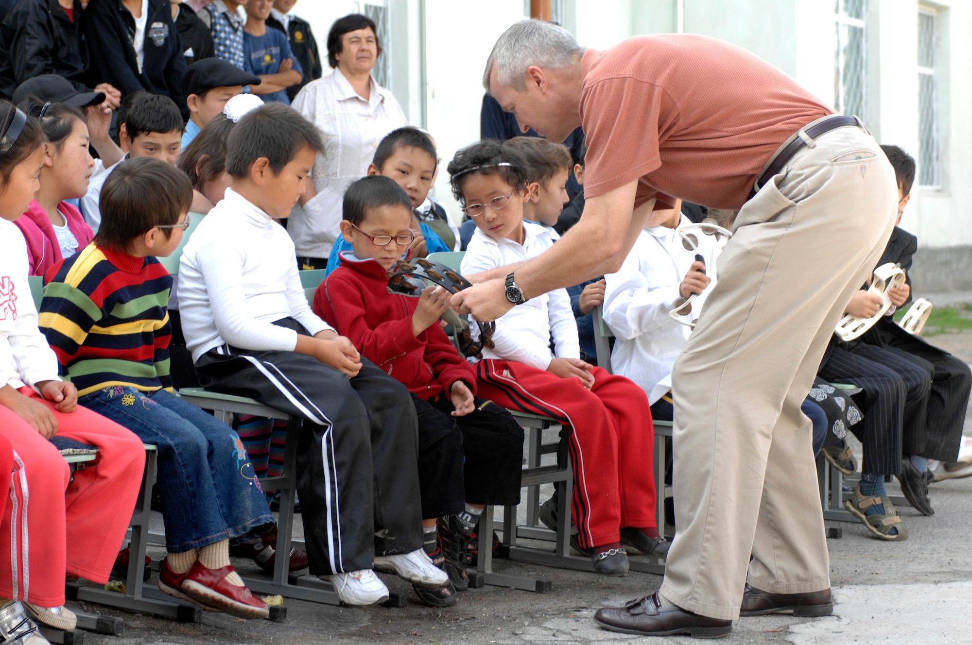 BISHKEK, Kyrgyzstan -- Lt. Col. Larry Lang, U.S. Air Forces Central Command 'Falcon' Band director, passes out tambourines to students at the Bishkek Boarding School for the Blind and Visually-Impaired Children on Sept. 28, 2009. Colonel Lang and the 'Falcon' Band members are stationed at a base in Southwest Asia and are deployed from Offutt Air Force Base, Neb.(U.S. Air Force photo/Senior Master Sgt. Andrew E. Lynch)