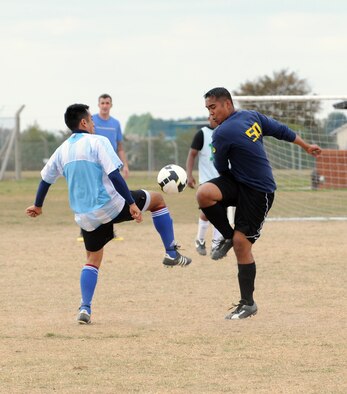 RAF MILDENHALL, England -- Miguel Valencia, 100th Logistics Readiness Squadron (left), and Albert Andres, 488th Intelligence Squadron, battle for control of the ball in an intramural soccer match near the Hardstand Fitness Center here Sept. 30. The teams finished regular play tied 3-3, but after a five-minute overtime session, 100th LRS took the game 6-3 against the combined 488th IS/95th Reconnaissance Squadron team. (U.S. Air Force photo/Senior Airman Thomas Trower) 