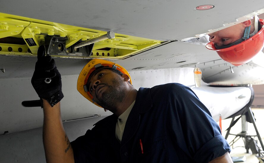 Senior Airman Malcolm Asher, right, watches as Staff Sgt. Brian Hart loosens 1 of 16 bolts securing the wing of an F-16C Falcon at Osan Air Base, Republic of Korea. The wing is being replaced due to corrosion and cracks found during a routine inspection.  Sergeant Hart and Airman Asher are aircraft fuel system technicians with the 51st Maintenance Squadron.  (U.S. Air Force photo/Staff Sgt. Brian Ferguson)
