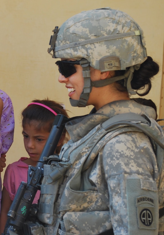 Army Spc. Ikram Mansori smiles as she is greeted by a group of Iraqi girls at an elementary school during a combined humanitarian assistance mission in Salman Pak, Iraq. Mansori speaks five languages, including Arabic. U.S. Army photo by Pvt. Jared Gehmann

