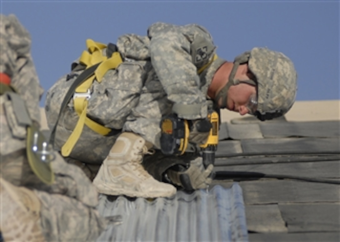 U.S. Army Pfc. Michael Papp, assigned to the 19th Engineer Battalion, installs tin sheets on a roof during a construction project at Kandahar Airfield, Afghanistan, on Sept. 14, 2009.  The 19th Engineer Battalion is forward-deployed to southern Afghanistan in support of Operation Enduring Freedom.  