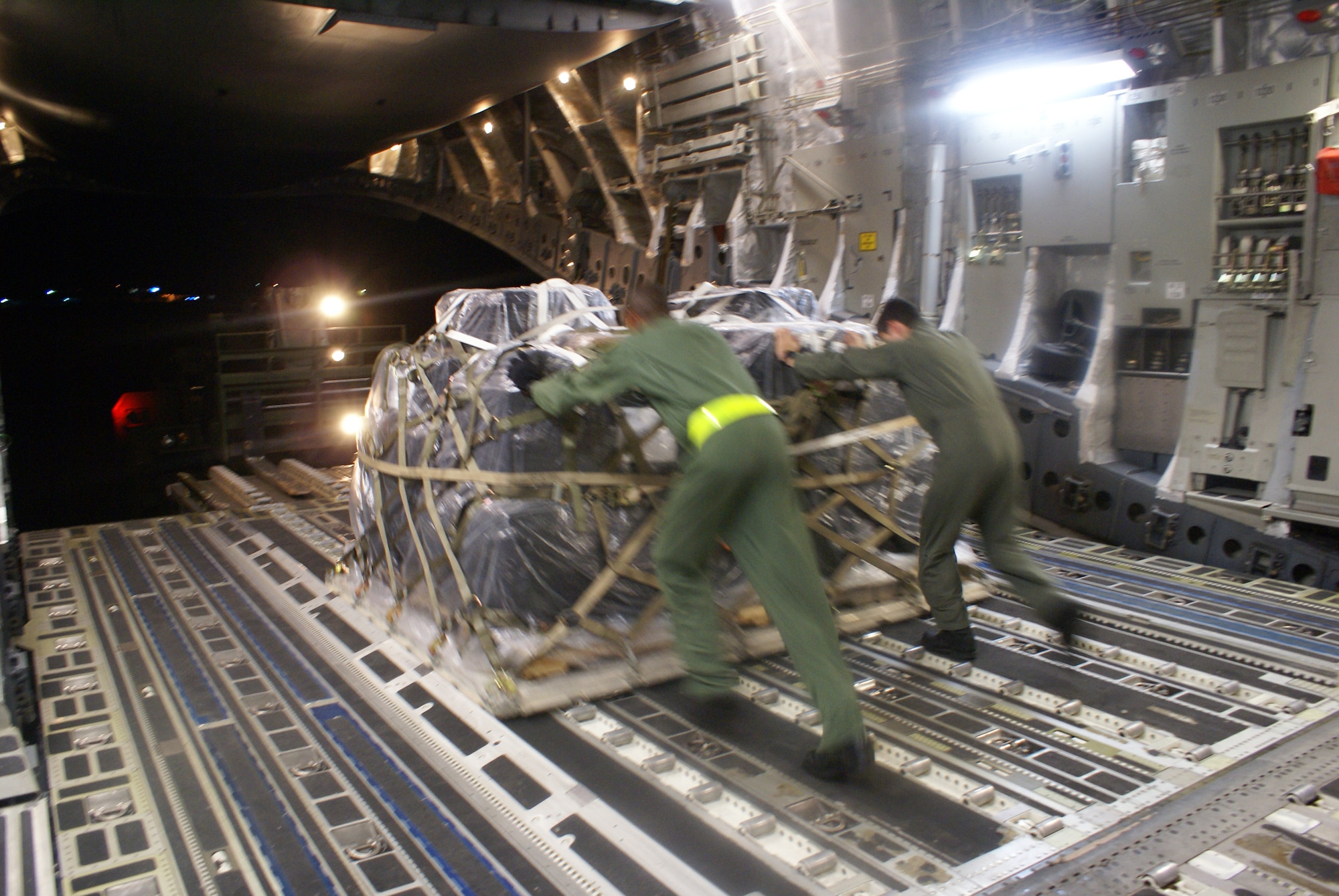 Tech. Sgt. Derrick Russell (left) and Senior Airman Jonathan Duarte, both 7th Airlift Squadron loadmasters from McChord Air Force Base, Wash., offload Federal Emergency Management Agency communications equipment from a McChord C-17 Globemaster III Oct. 2, 2009, at Pago Pago International Airport, American Samoa. (U.S. Air Force photo/Staff Sgt. Eric Burks)          