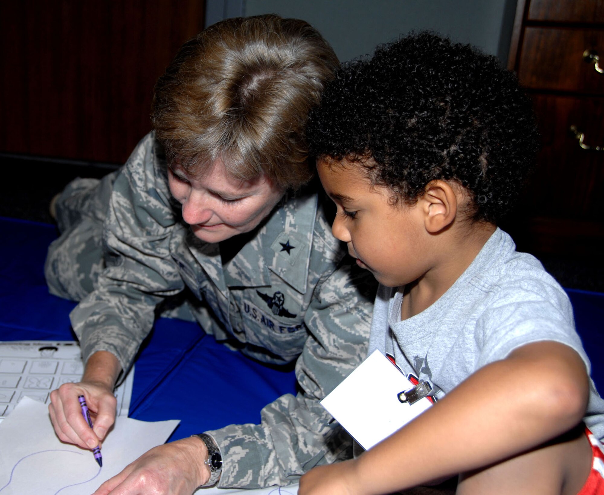 349th Air Mobility Wing Commander Brig. Gen. Maryanne Miller draws a picture for a toddler during the wing's first Yellow Ribbon Reintegration conference Sept. 26, 2009. The events, sponsored by the 349th Maintenance Group, included briefings, booths and prizes for parents, games, goodies and pizza for children of all ages, and a spaghetti dinner and town hall meeting with a question and answer session for all. The YRRP is a DOD sanctioned entity that provides support and assistance to families pre-, during and post-deployment. (U.S. Air Force photo/SMSgt. Ellen L. Hatfield).