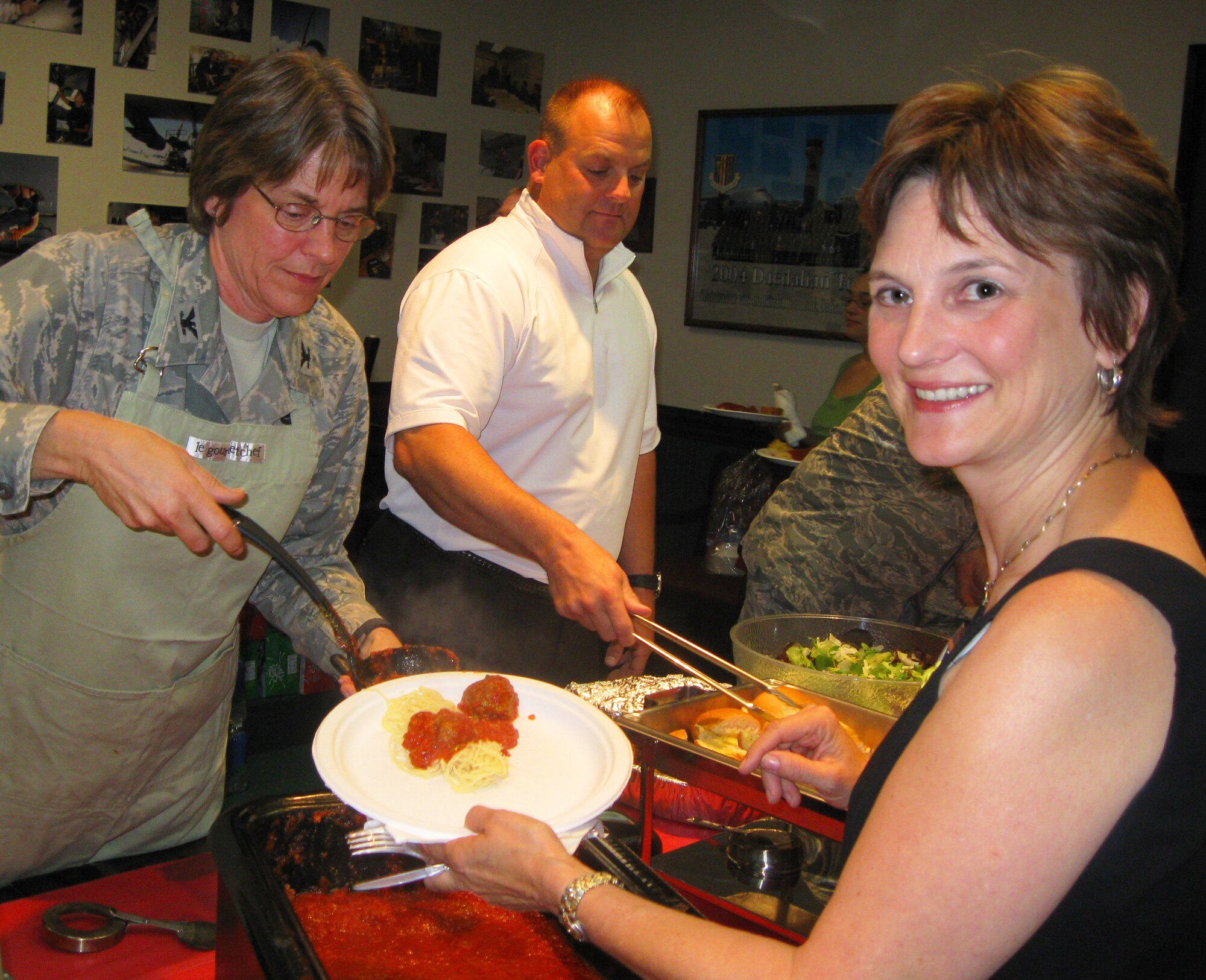Col. Nancy Brooks, 349th Mission Support Group commander (left) dishes up meatballs for the spaghetti at the 349th Air Mobility Wing?s Yellow Ribbon Reintegration Program conference Sept. 26, 2009. The event was in support the families of personnel who deployed during the past year. Mrs. Marcy Anholt (right) was the guest speaker, and facilitator for the town hall meeting. The 349th Maintenance Group hosted the event, which included briefings, games, prizes, and activities for children of all ages. Wrapping up the day was a free spaghetti dinner and Town Hall meeting with a question and answer session. (U.S. Air Force photo/Command Chief Master Sgt. Kathleen Buckner) 