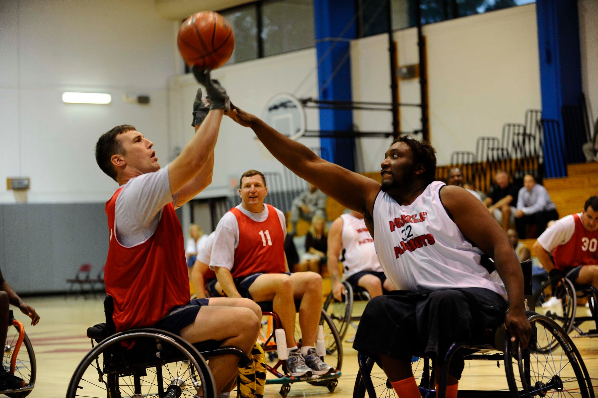 Maj. Shane Vesely, 1st Special Operations Wing executive officer, attempts to shoot a basket over the defense of a member of the Mobile Patriots, a National Wheelchair Basketball Association team, at the fourth annual Wheelchair Basketball Exhibition Game at the Aderholt Fitness Center at Hurlburt Field Oct. 1. (U.S. Air Force photo by Senior Airman Julianne Showalter)
