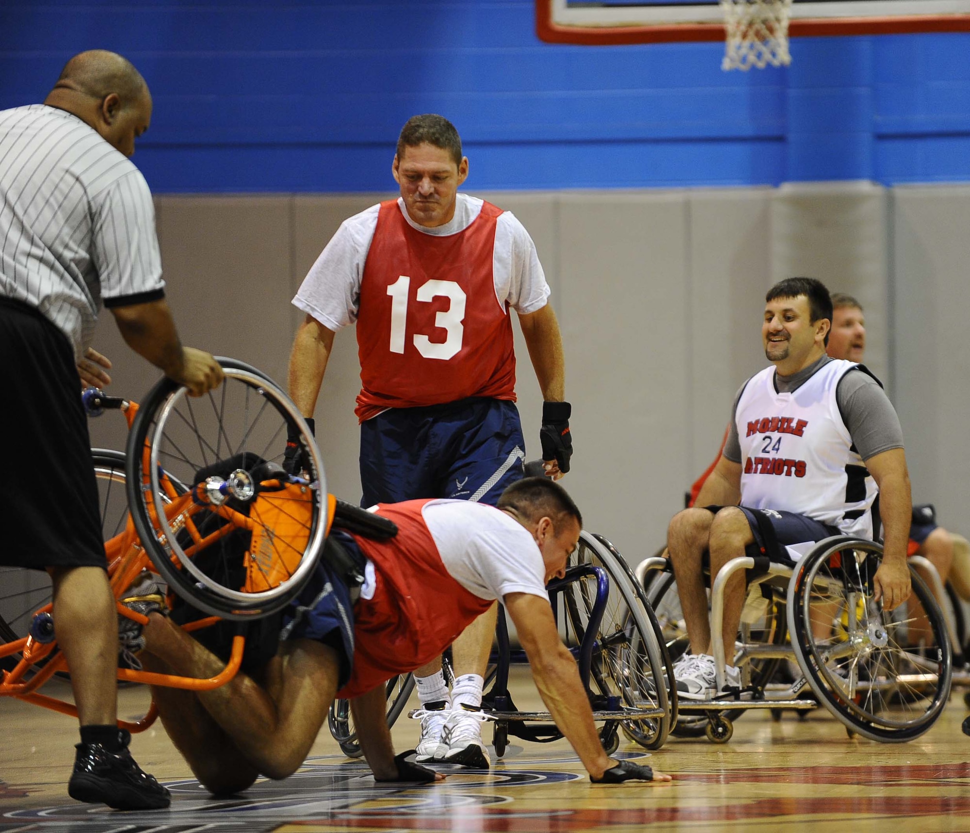 Col. Ben McMullen, acting 1st Special Operations Wing vice commander, attempts to help Capt. Ben Self, 1st Special Operation Wing executive officer, recover from his tipped-over wheelchair at the fourth annual Wheelchair Basketball Exhibition Game at the Aderholt Fitness Center at Hurlburt Field Oct. 1.  (U.S. Air Force photo by Senior Airman Julianne Showalter)