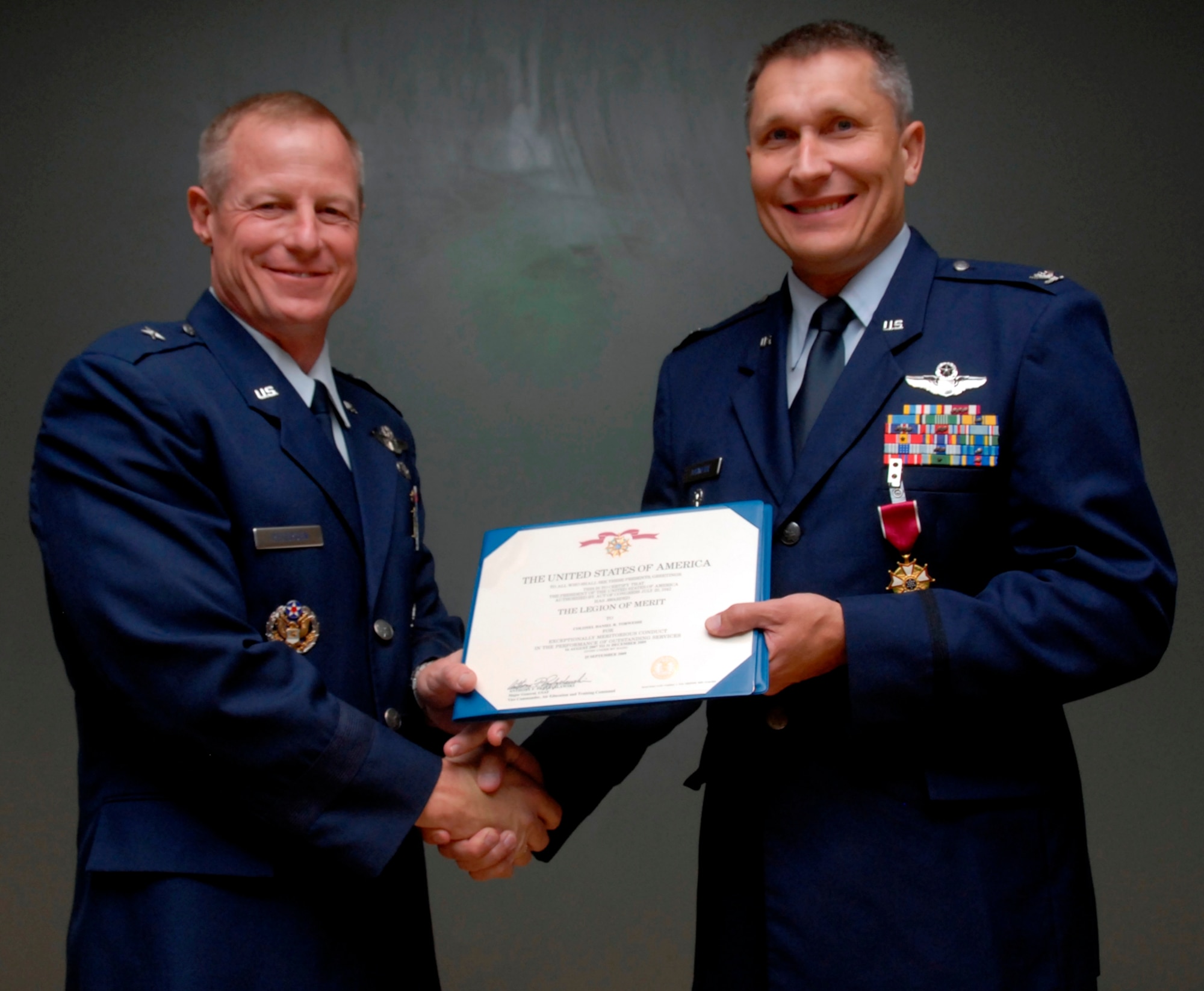 Col. Daniel Torweihe (right), former 80th Flying Training Wing vice commander, accepts the Legion of Merit from Brig. Gen. David Petersen, former commander of the 80th FTW, at the colonel’s retirement ceremony Oct. 2 at the large auditorium in Bldg. 1900. (U.S. Air Force photo/Mike Litteken)