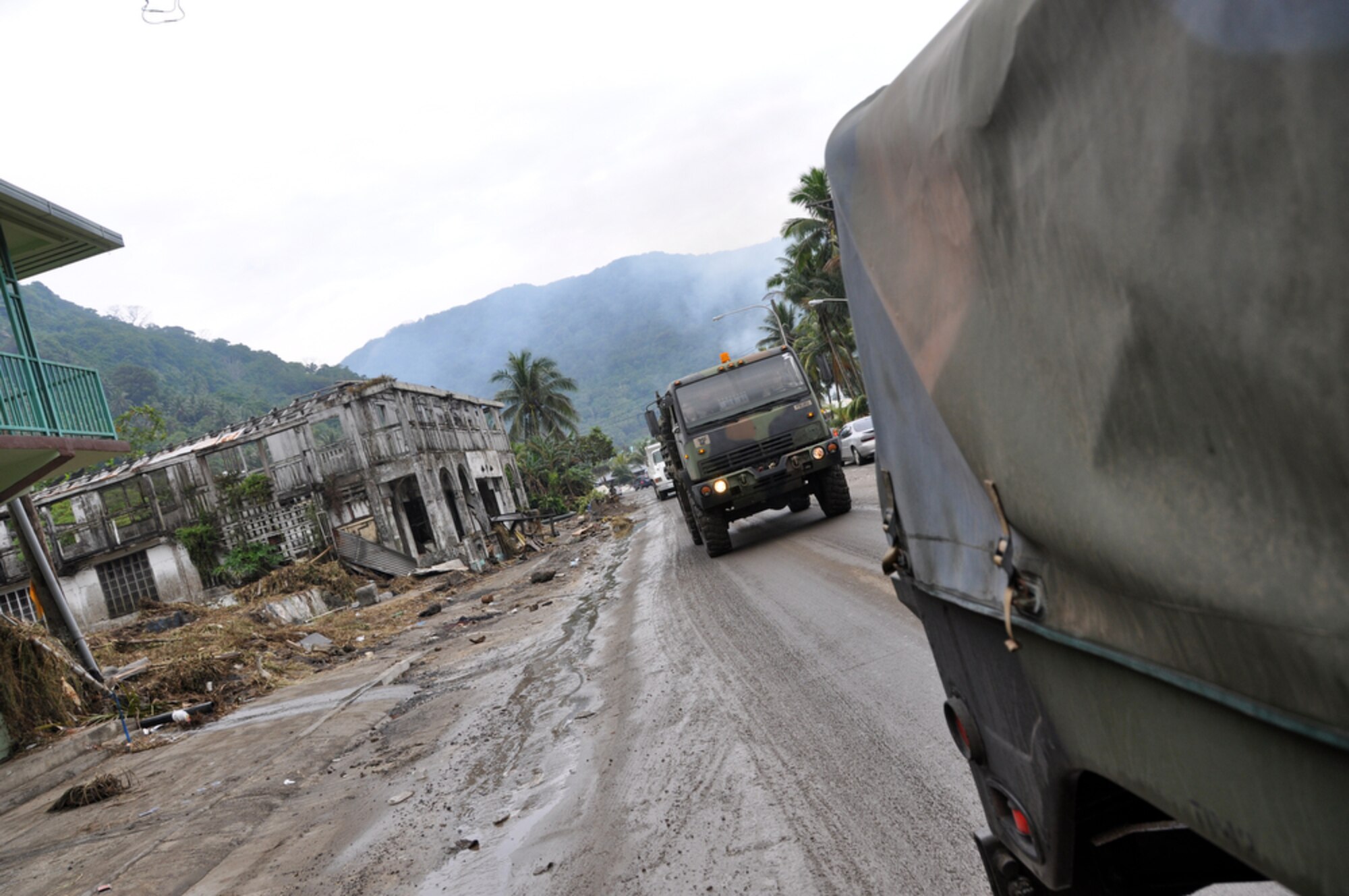 PAGO PAGO - 154th Medical Group, U.S. Air National Guardsmen and 93rd Civil Support Team, U.S. Army National Guardsmen personnel drive past homes and businesses left in ruins along the main road of Pago Pago, American Samoa on Oct. 1, 2009 after a tsunami caused a great amount of structural damage to the island and it's villages Sept. 29, 2009. (U.S.  Air Force photo/Tech Sgt. Cohen A. Young)