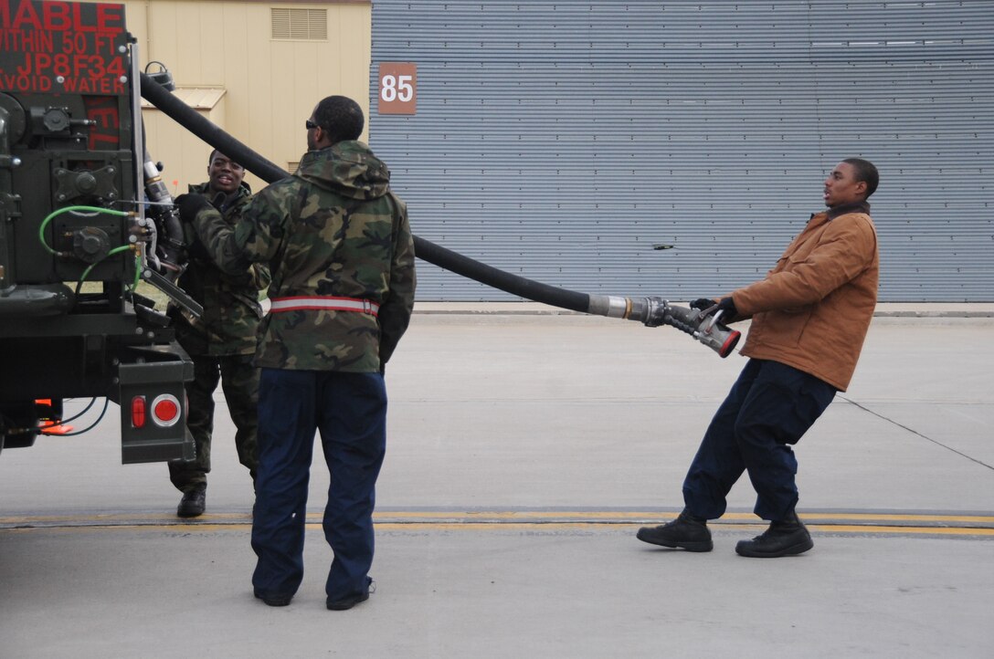 (Left to right) Airmen 1st Class Samuel Carr, Brandon Bryant and Senior Airman DeQuan Mchatten, 28th Aircraft Maintenance Squadron crew chiefs, pull out fuel lines before fueling a B-1B Lancer here, October 1.  The crew chiefs maintain and refuel B-1s, the backbone of America's long-range bomber force. (U.S. Air Force photo/Airman 1st Class Anthony Sanchelli)
