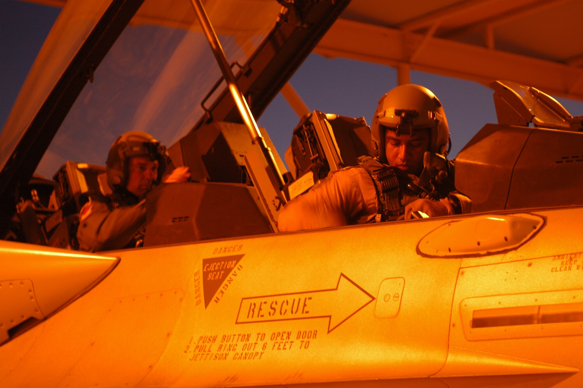 A student pilot from the United Arab Emirates Air Force straps into an F-16F Desert Falcon on the 162nd Fighter Wing flightline with an instructor pilot in the back seat. The UAE is the only partner nation currently training with the 162nd to use night vision goggles during flight. (Air National Guard photo by Maj. Gabe Johnson)