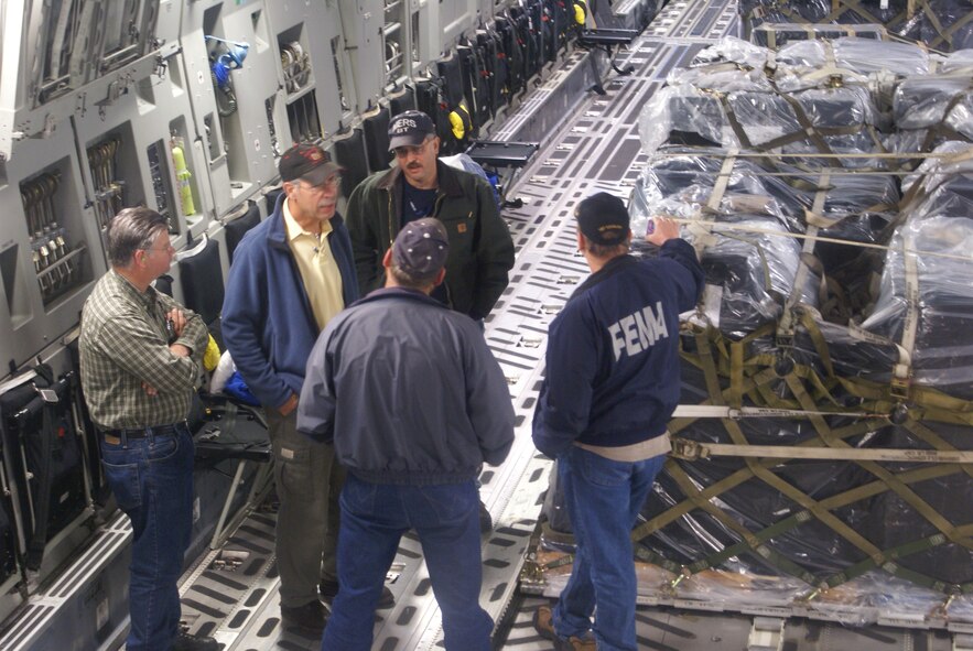 Federal Emergency Management Agency discuss their mission onboard a McChord C-17 Globemaster III after arriving in Pago Pago, American Samoa Oct. 1. The mission was McChord’s first airlift to the Samoan Islands in support of humanitarian relief efforts. (U.S. Air Force photo/Staff Sgt. Eric Burks)