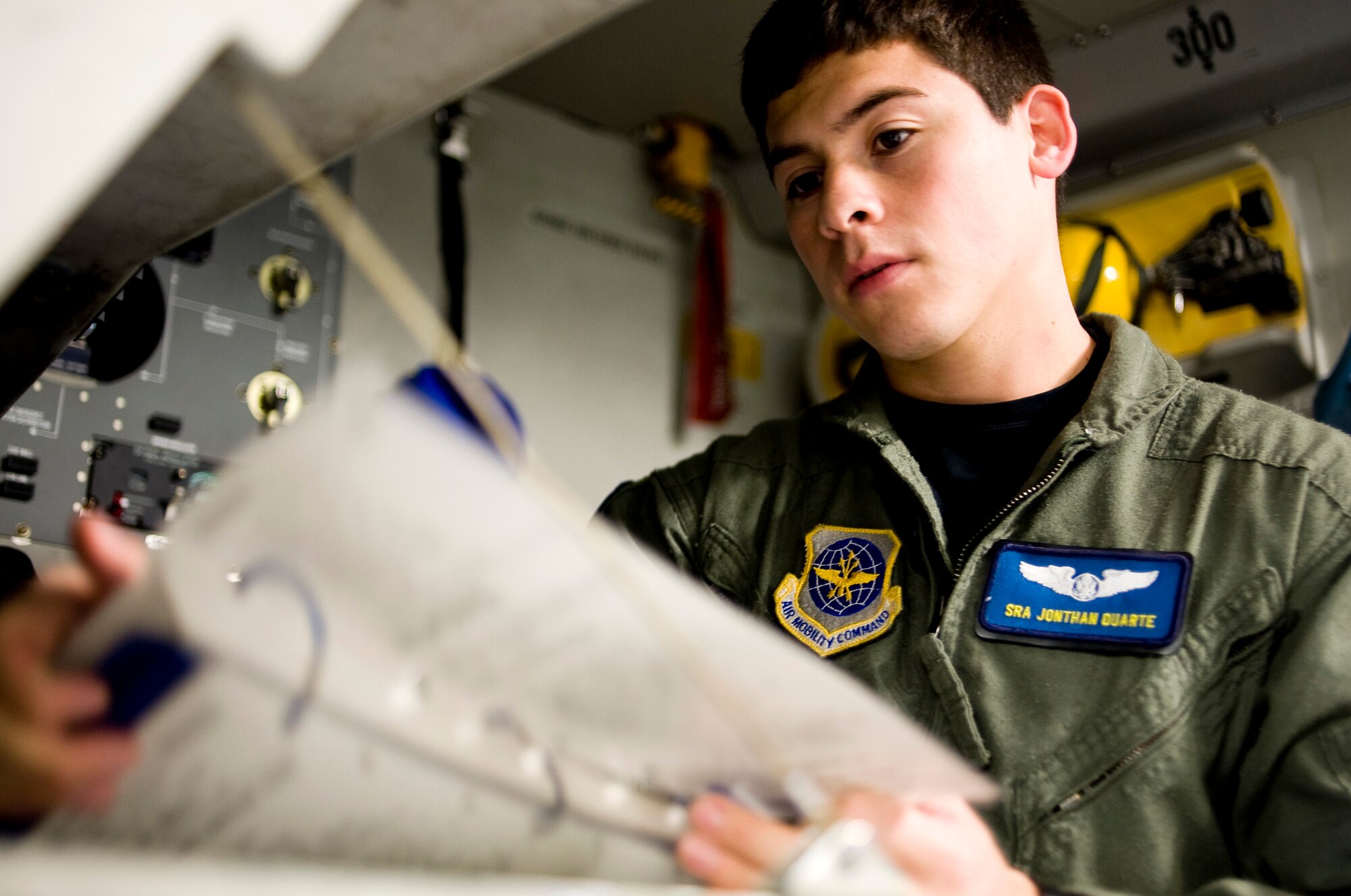Senior Airman Jonathan Duarte reviews a preflight checklist aboard a C-17 Globemaster III Oct 1, 2009, at McChord Air Force Base, Wash. In the wake of a 7.6 magnitude undersea earthquake that caused a devastating tsunami to strike American Samoa, McChord AFB Airmen deployed a U.S.-based Federal Emergency Management Agency team to the region at 2 p.m. Oct. 1 aboard a C-17. Airman Duarte is assigned to the 7th Airlift Squadron. (U.S. Air Force photo/Abner Guzman) 