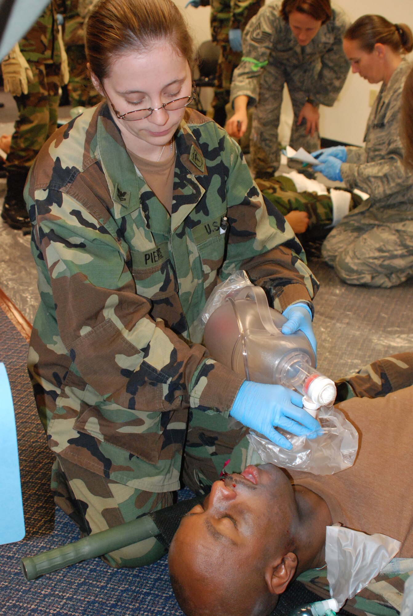 Navy Medical corpman, HM/E2 Marianne Peirce, treats a military member while other Air Force and Navy medical technicians treat patients around her during the first NAS JRB Ft Worth Air Force and Navy Reserve joint medical exercise. (U.S. Air Force photo/TSgt Stephen C. Bailey)