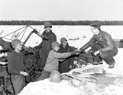 All smiles as Capt. Lowell Smith thanks a U.S. Army antiaircraft crew for their help. Smith had been attacked by a Bf 109 while returning from a mission. With no ammunition left, he flew low over this gun position, and the crew shot the enemy fighter down. (U.S. Air Force photo)